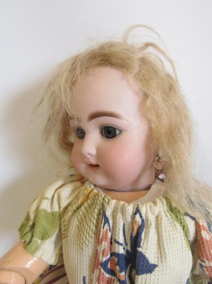 A Simon & Halbig bisque head doll with blue glass sleeping eyes Image