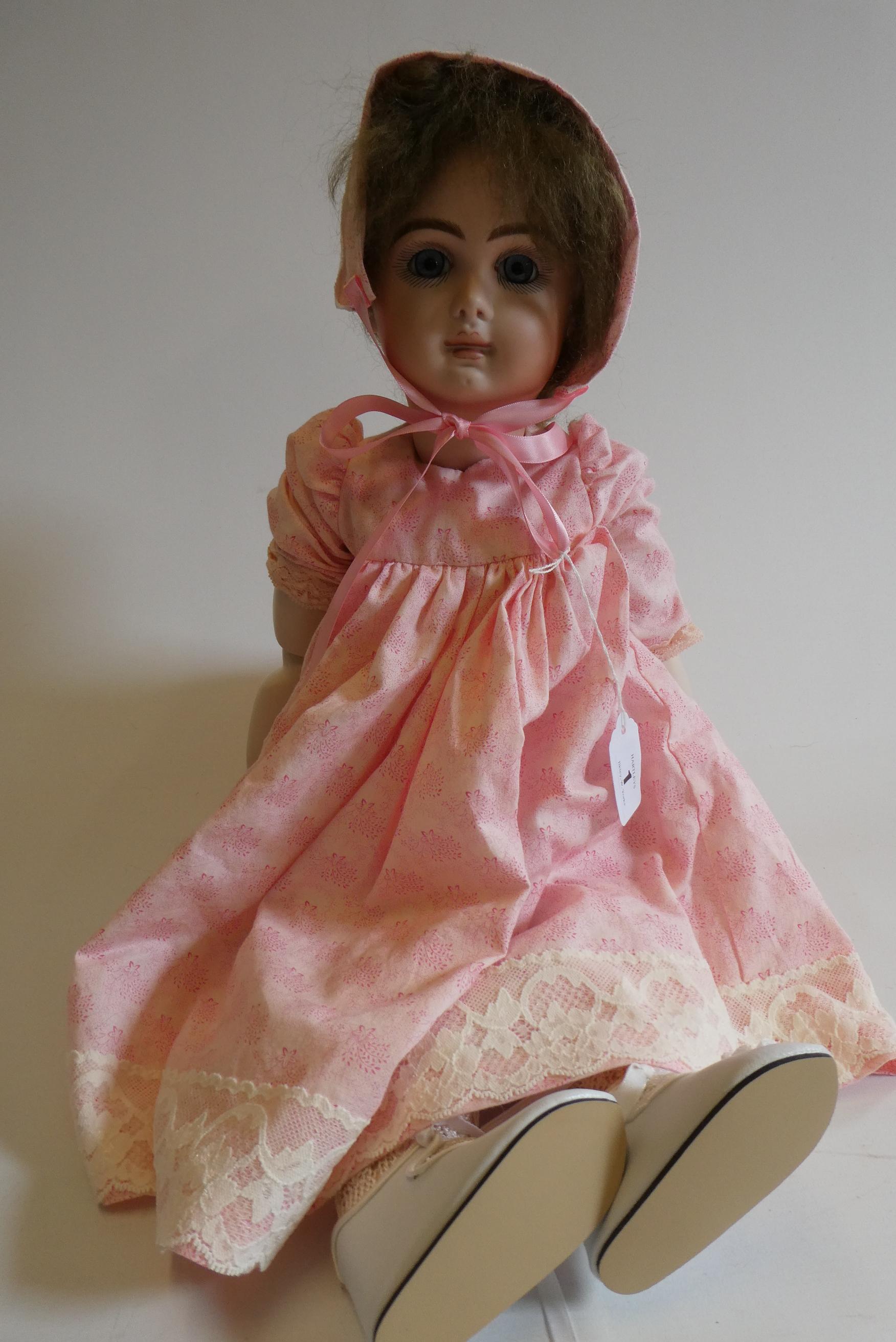 A reproduction "Jumeau" bisque socket head doll with blue glass fixed eyes Image