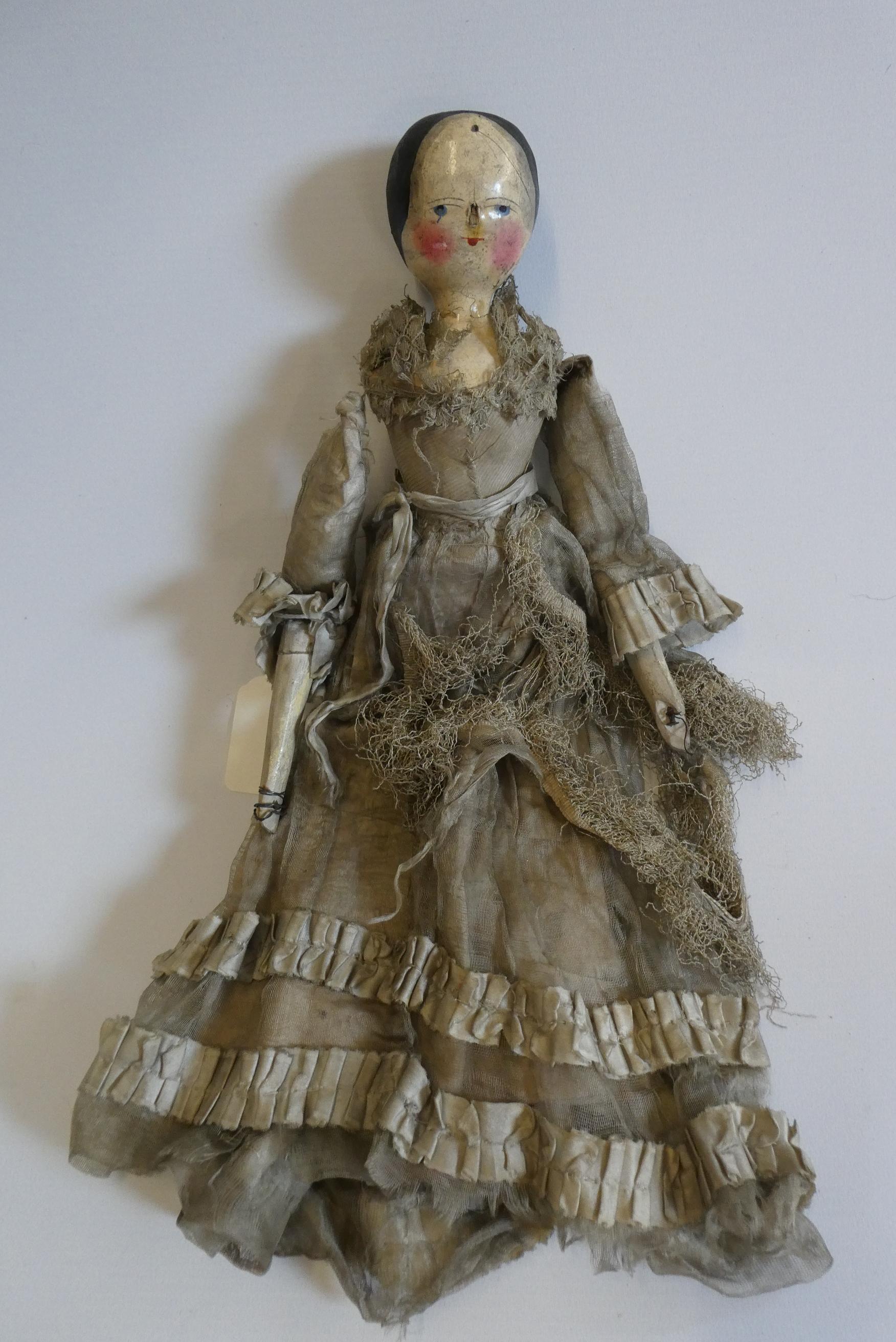 A Victorian peg doll with carved and painted head and torso, cloth upper limbs and carved wooden Image