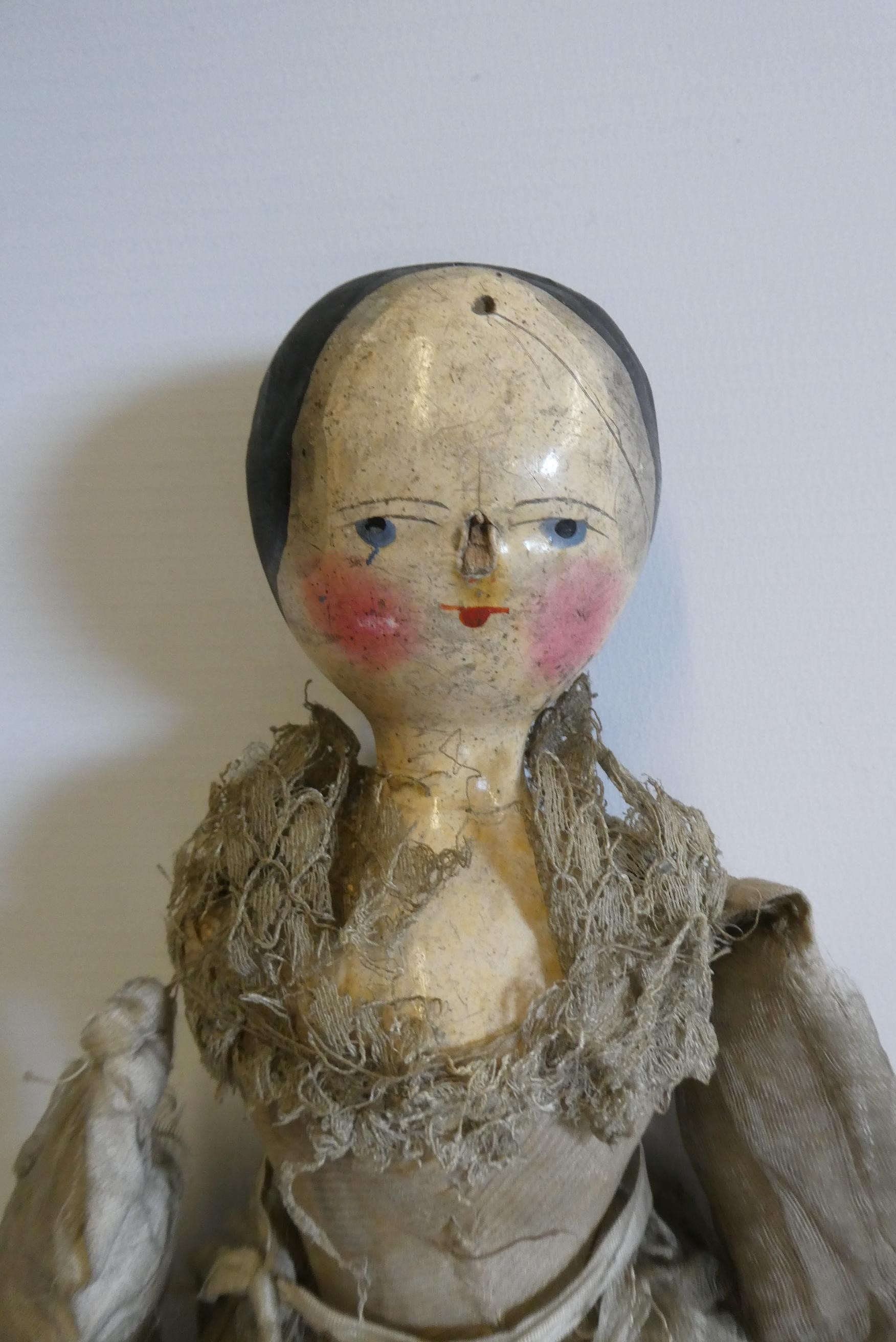 A Victorian peg doll with carved and painted head and torso, cloth upper limbs and carved wooden Image