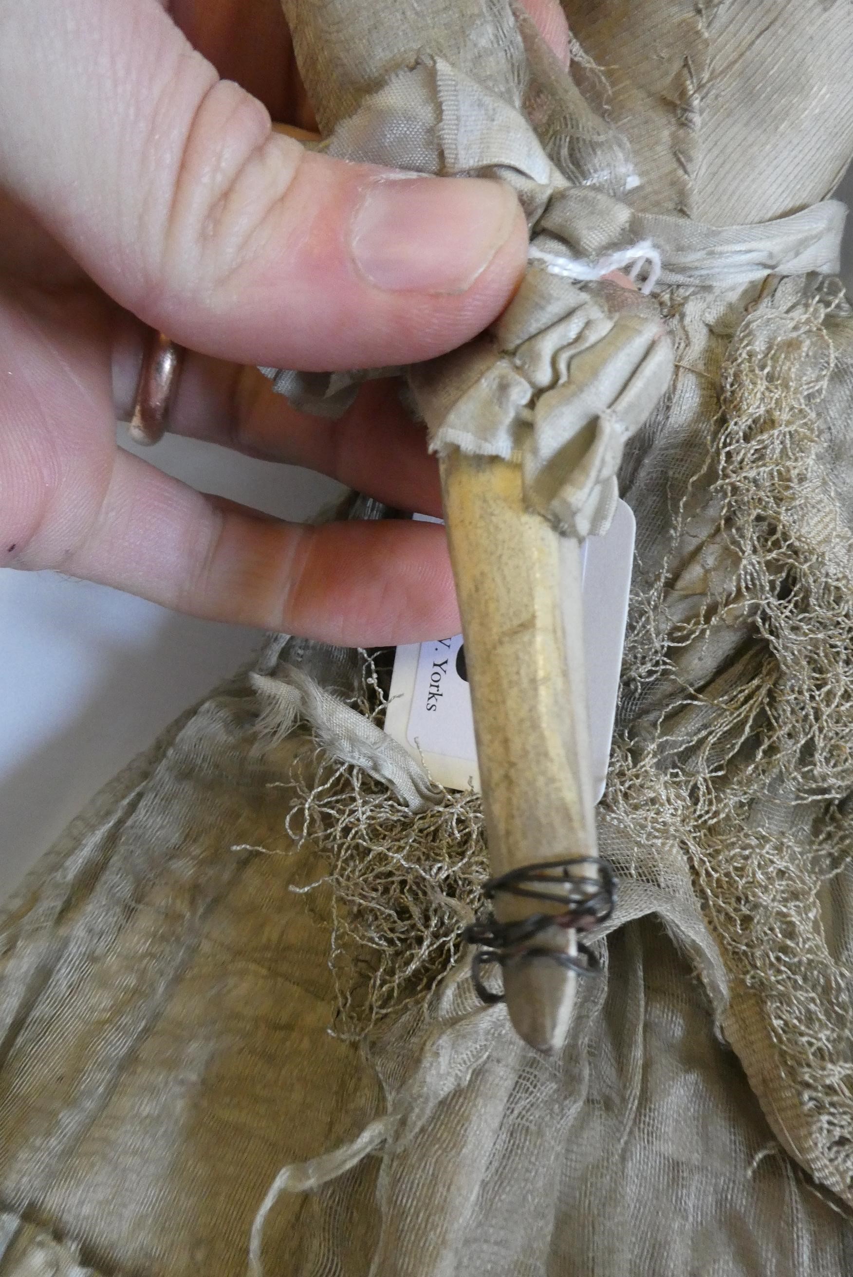 A Victorian peg doll with carved and painted head and torso, cloth upper limbs and carved wooden Image