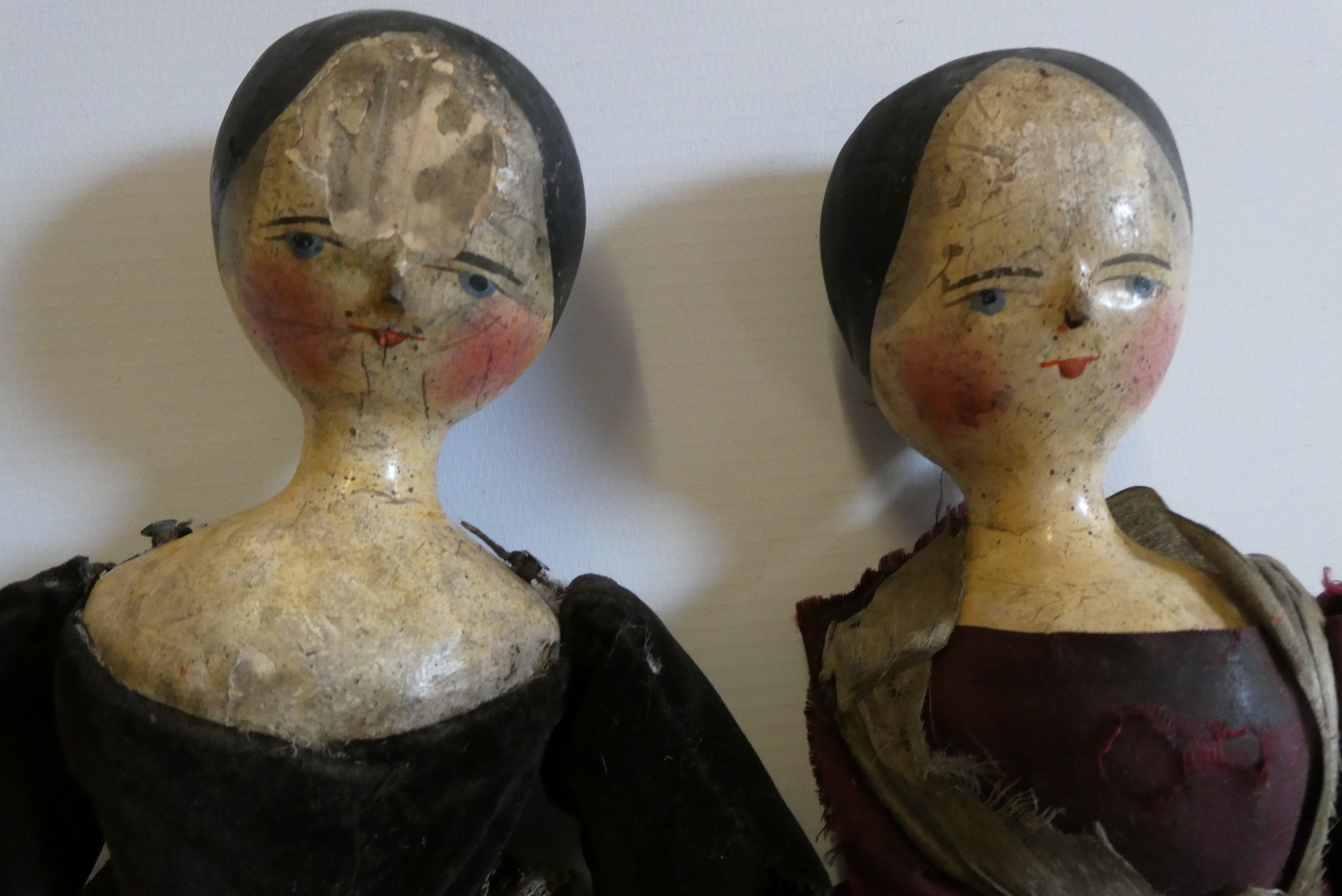 Two Victorian peg dolls with carved and painted head and torso, cloth upper limbs and carved wooden Image