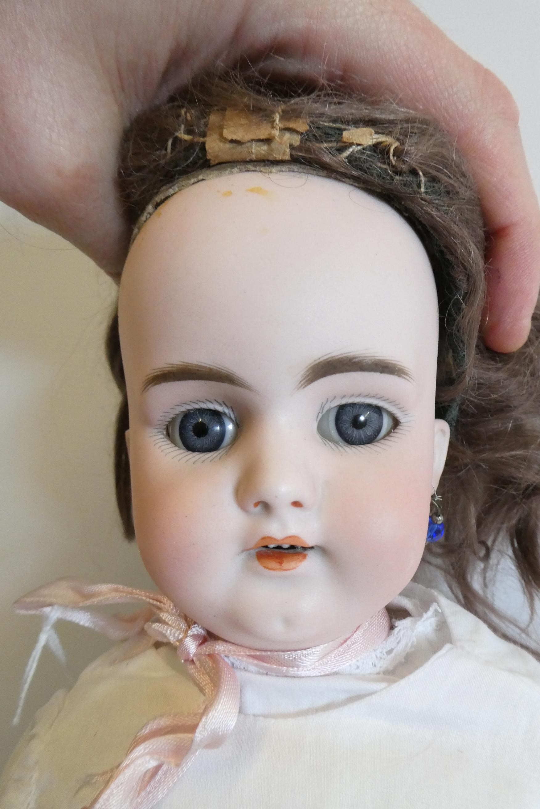 A Simon & Halbig bisque socket head doll with blue glass fixed eyes Image