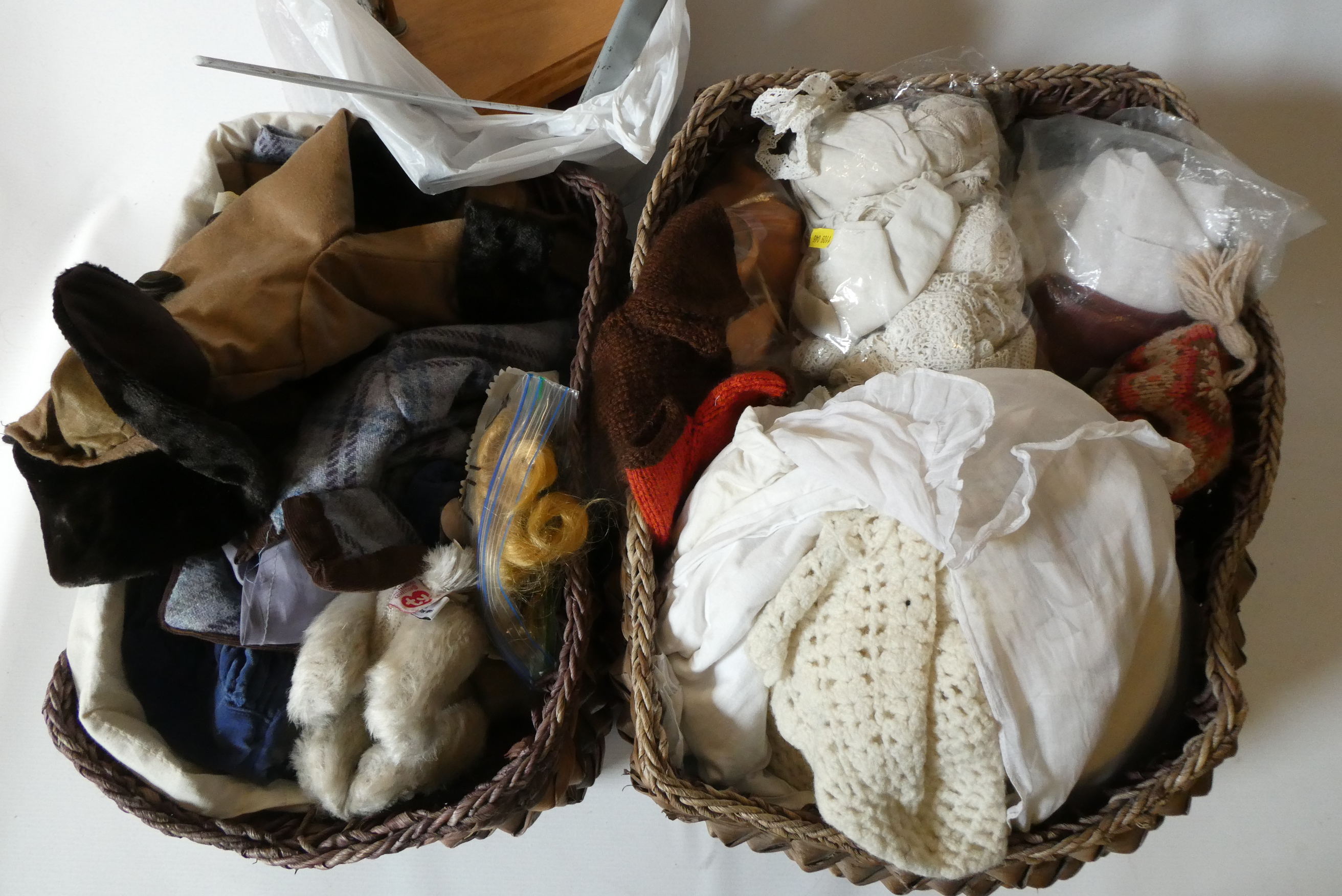 Two baskets of dolls clothing, spare parts and doll stands (Est. plus 24% premium inc. VAT) Image