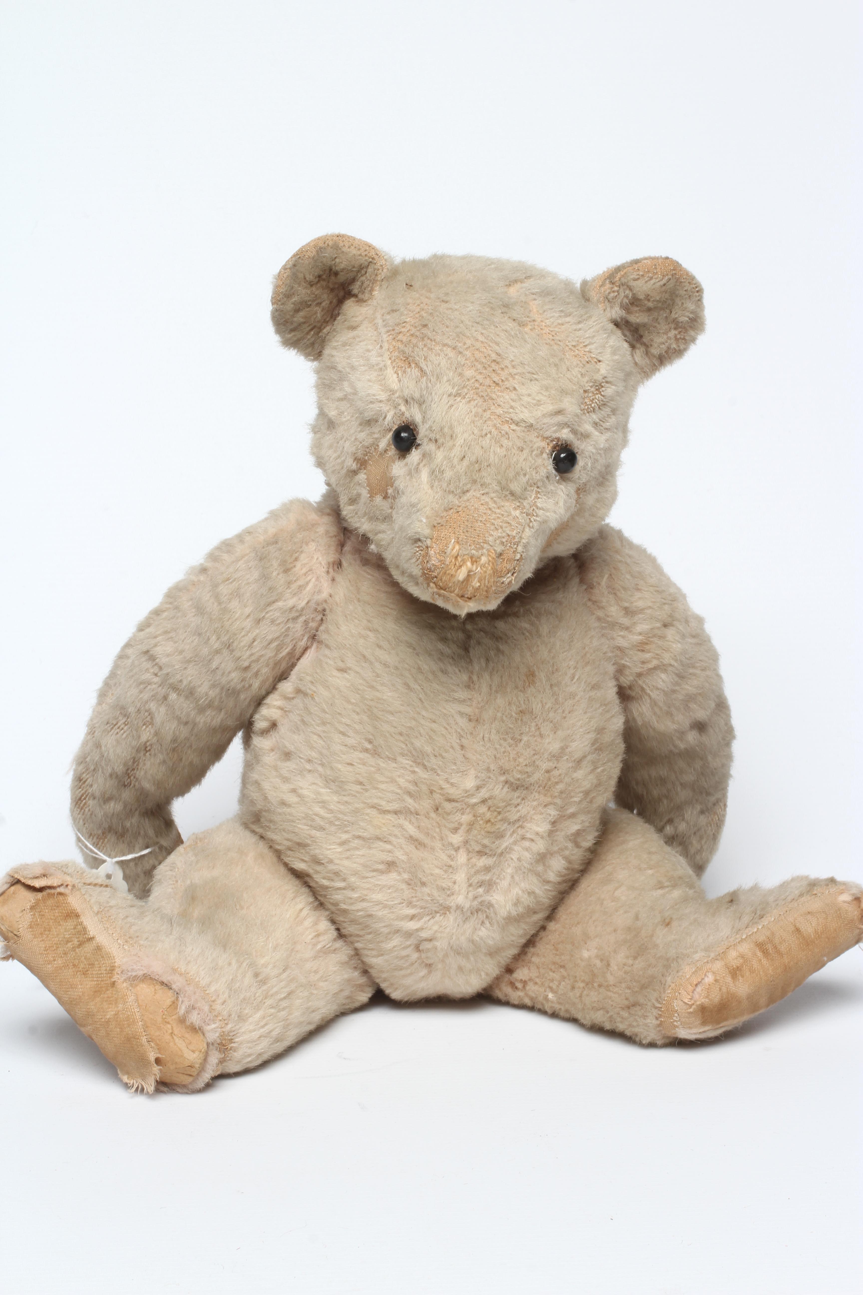 A pre-war pink jointed teddy bear, with shoe button eyes, sewn nose and cloth pads, 16" long (Est. Image