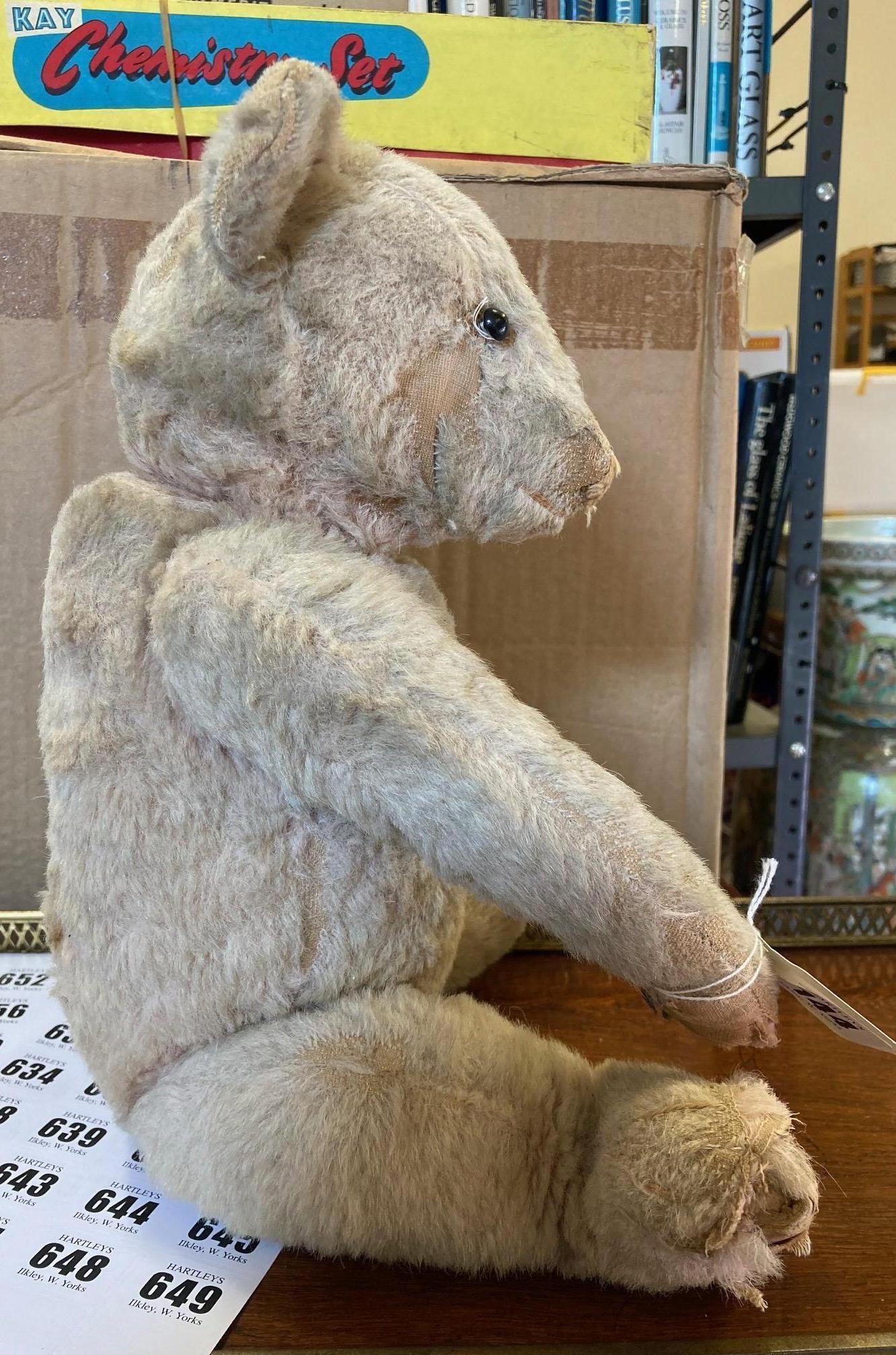 A pre-war pink jointed teddy bear, with shoe button eyes, sewn nose and cloth pads, 16" long (Est. Image