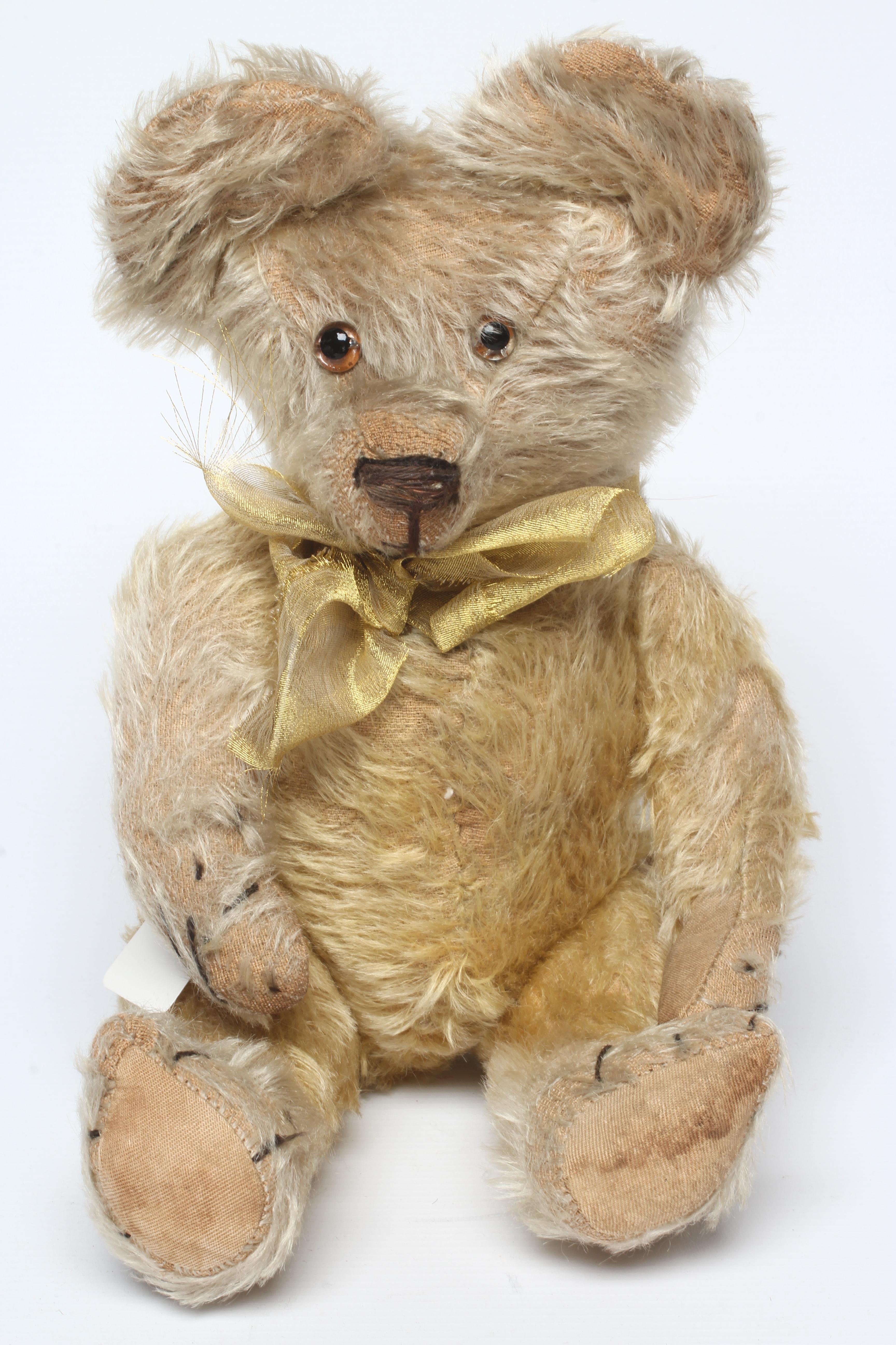 Blond mohair jointed teddy bear, c.1920, with clear glass eyes, sewn nose, large ears and cloth Image