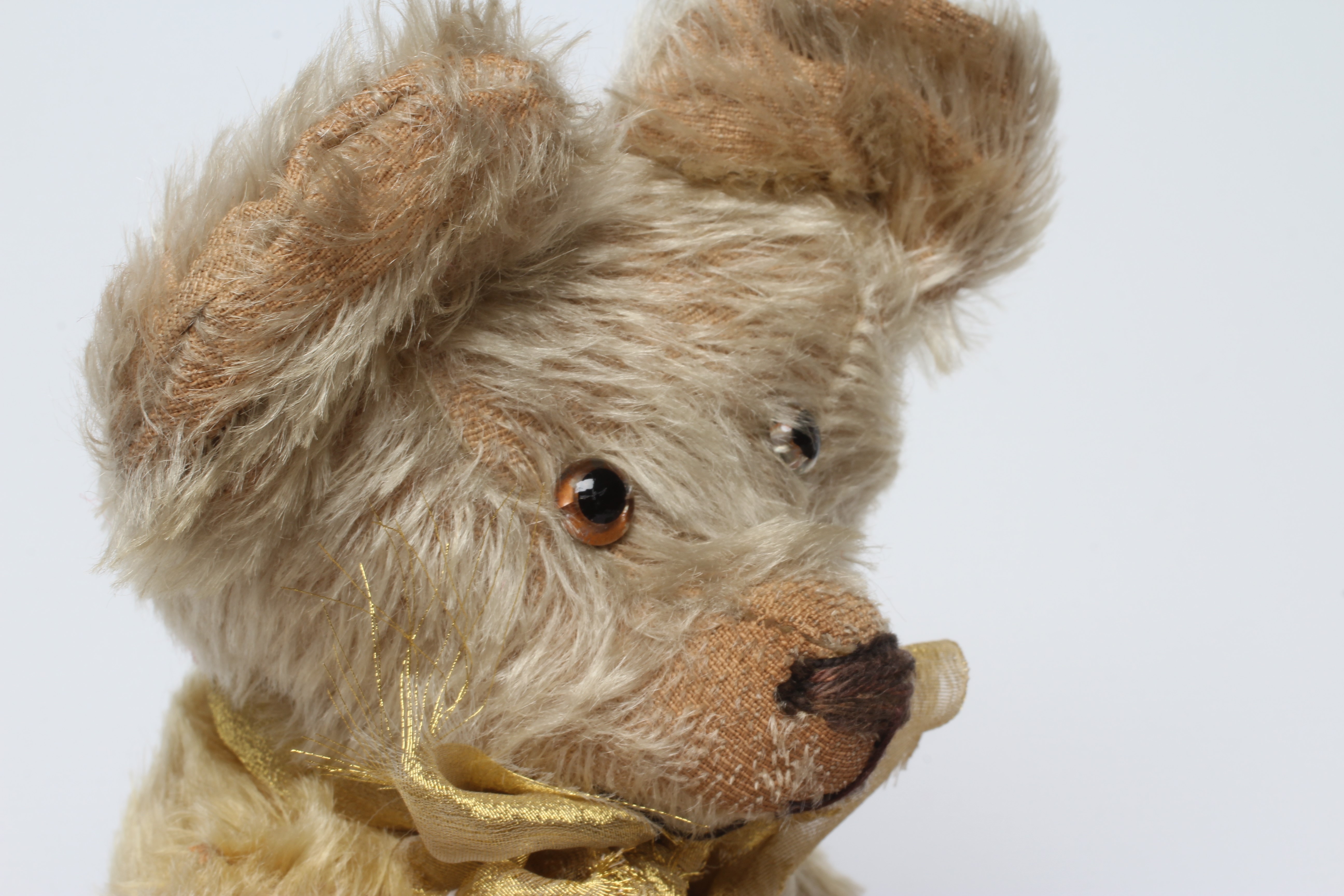 Blond mohair jointed teddy bear, c.1920, with clear glass eyes, sewn nose, large ears and cloth Image