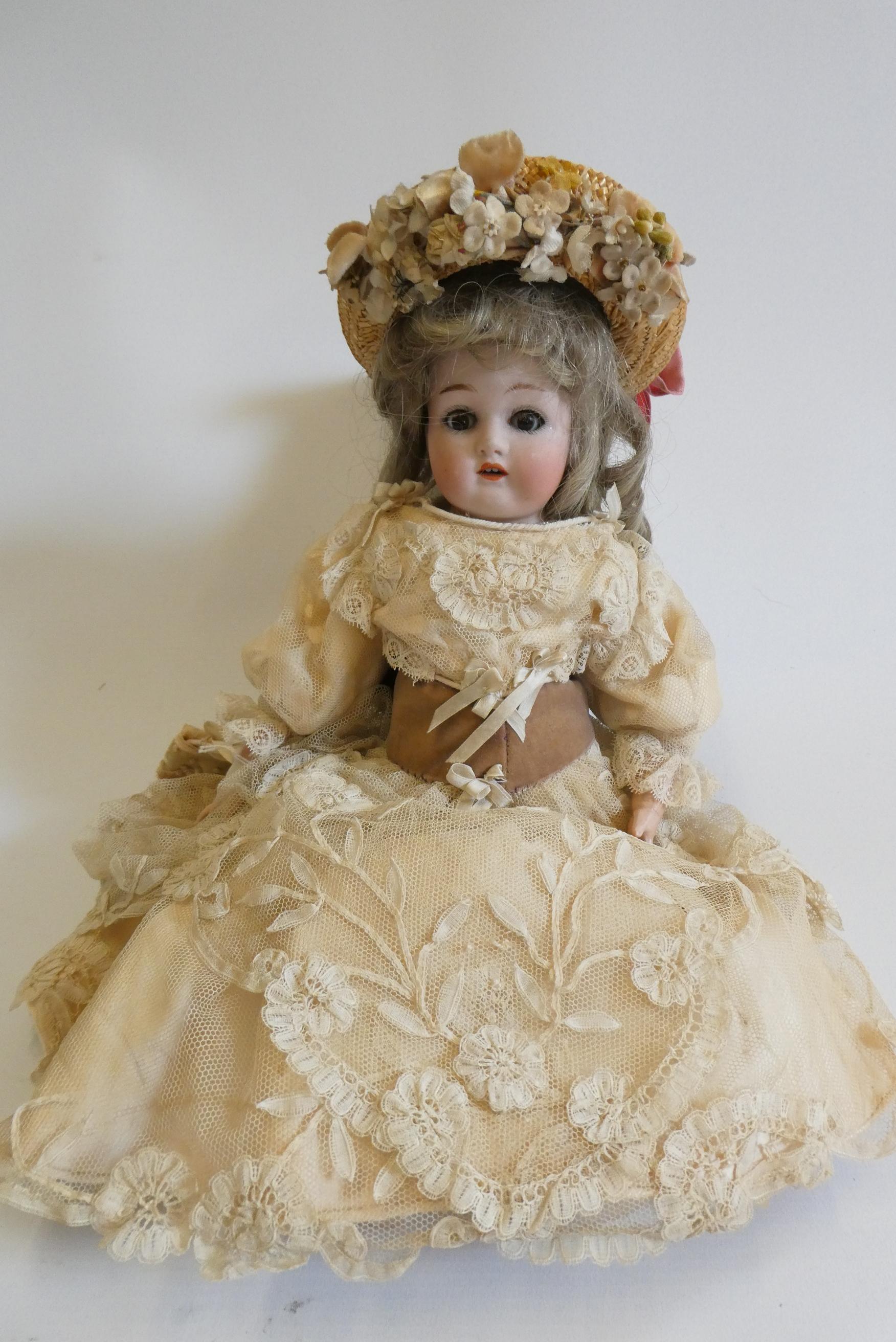 A Wagner & Zetsche bisque shoulder head doll with brown glass fixed eyes Image