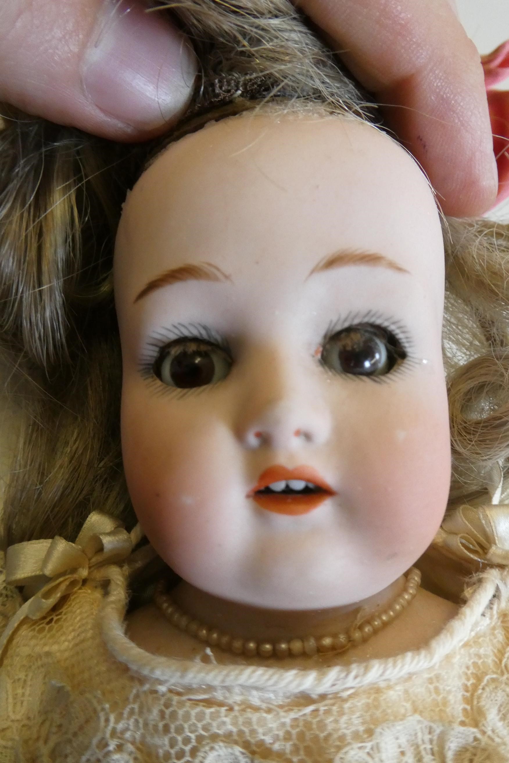 A Wagner & Zetsche bisque shoulder head doll with brown glass fixed eyes Image