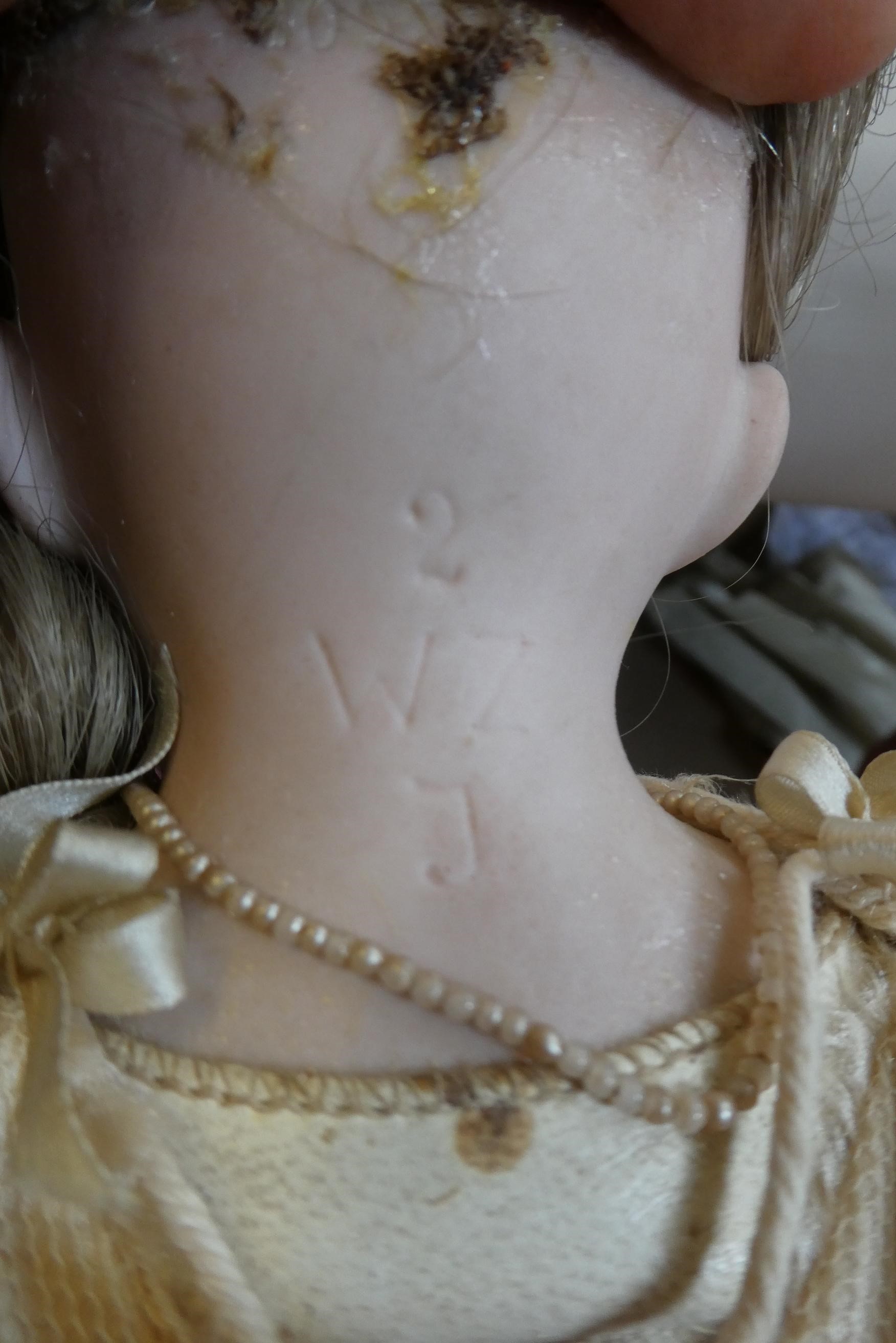 A Wagner & Zetsche bisque shoulder head doll with brown glass fixed eyes Image