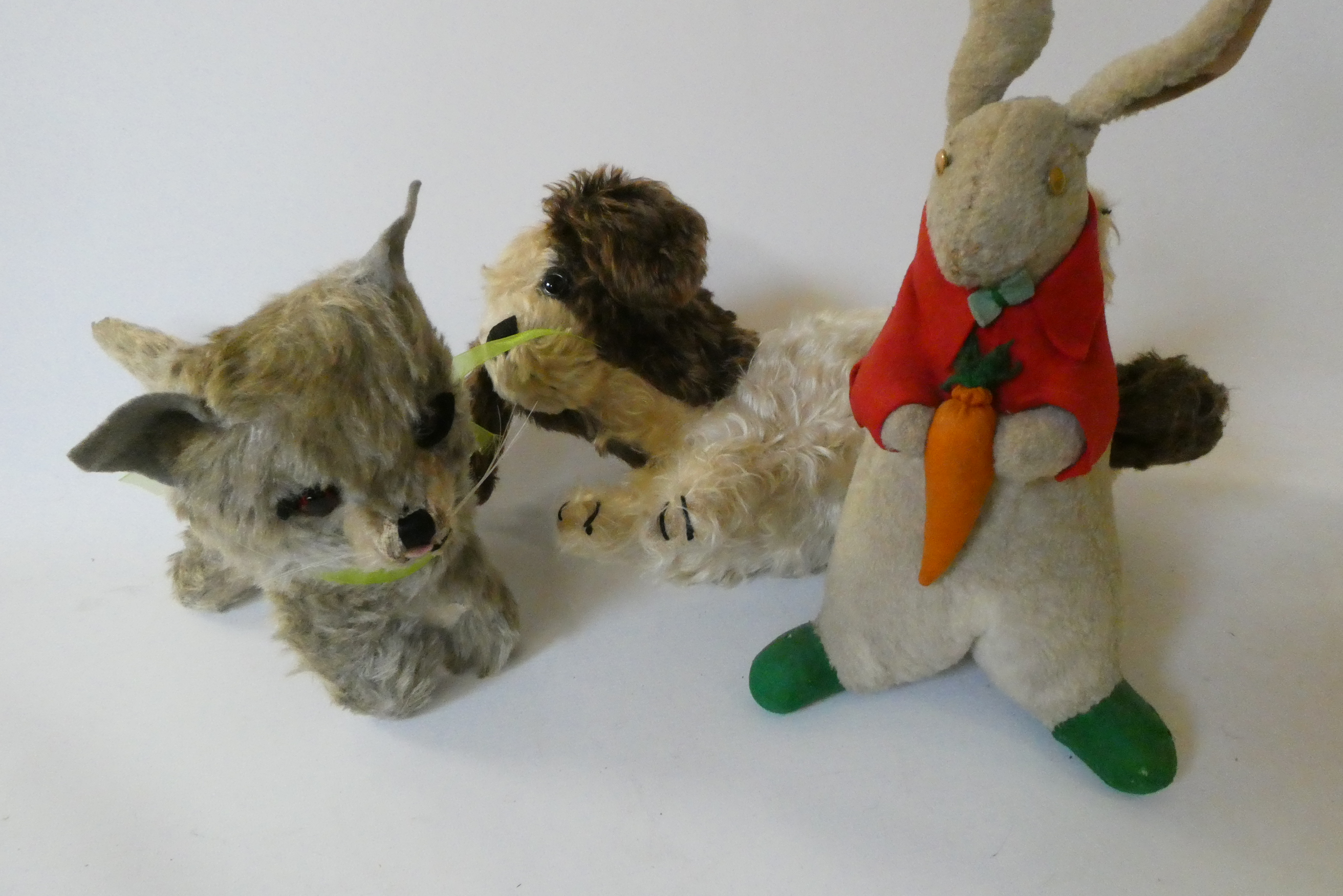 Three vintage plush toys, comprising a Chiltern cat with felt ears and tongue, a puppy pyjama case Image