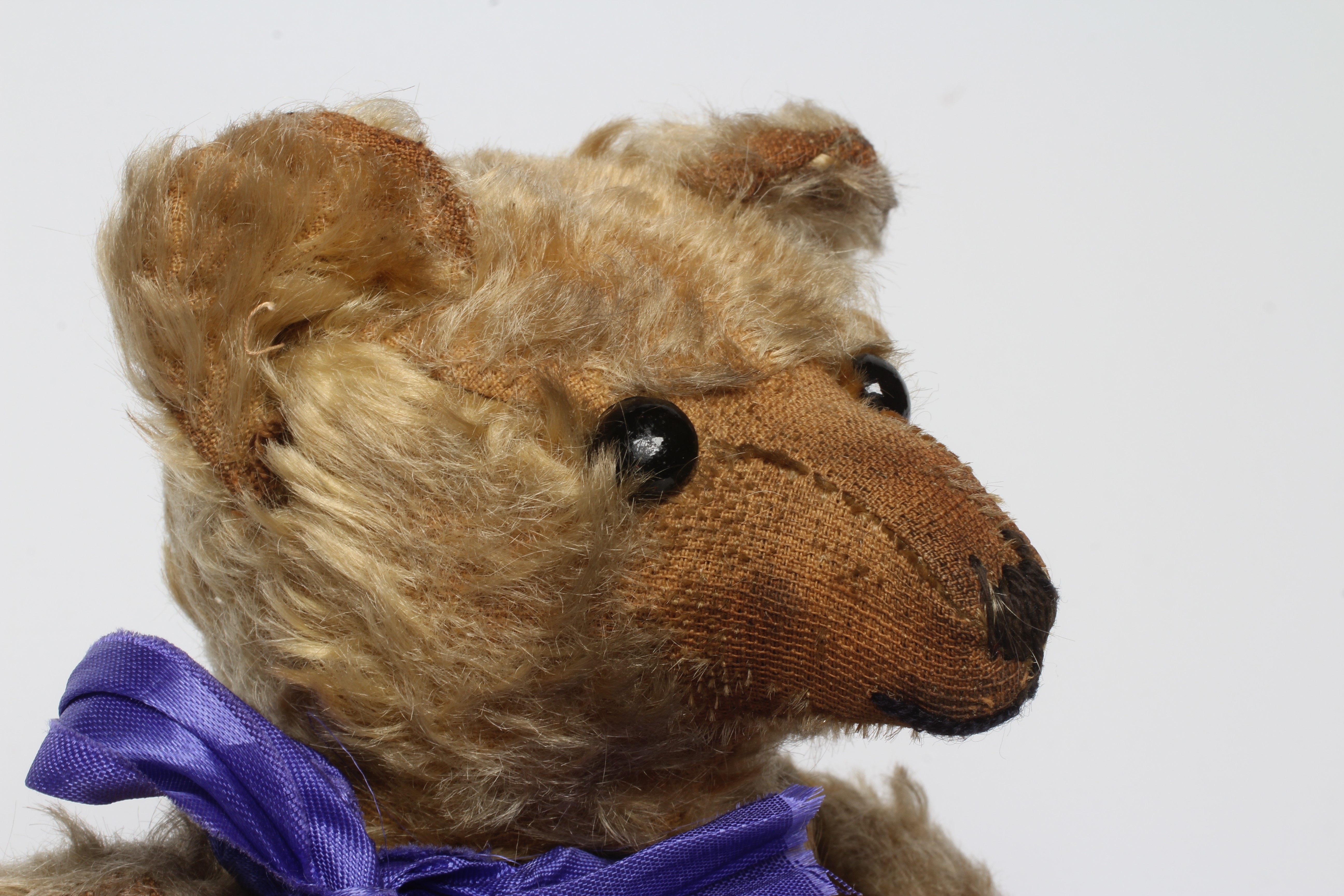 A mohair jointed teddy bear, c.1910, with shoe button eyes, sewn nose, long nose and cloth pads, 14" Image