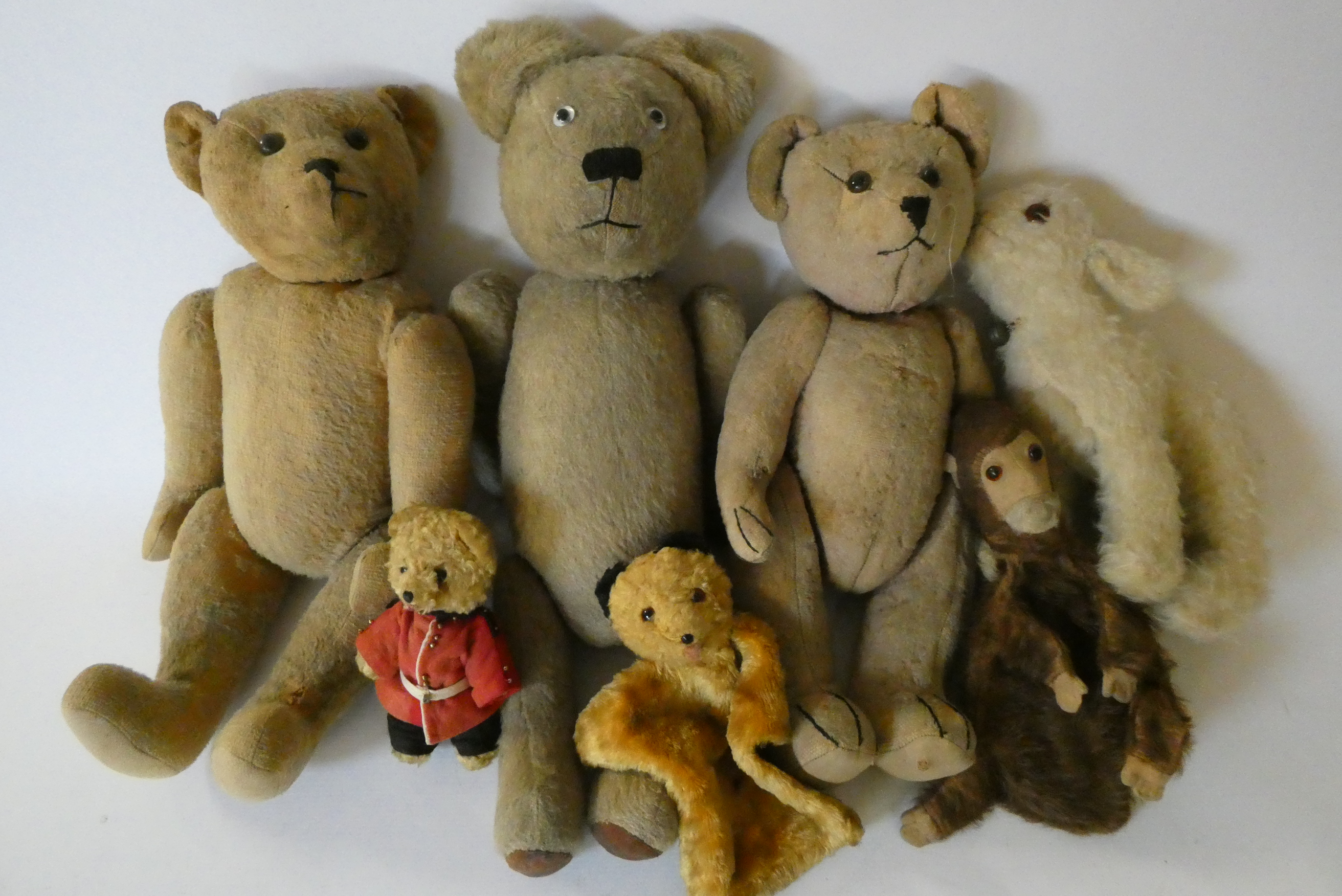 Seven vintage plush toys comprising three large teddy bears, one small soldier bear, two puppets Image
