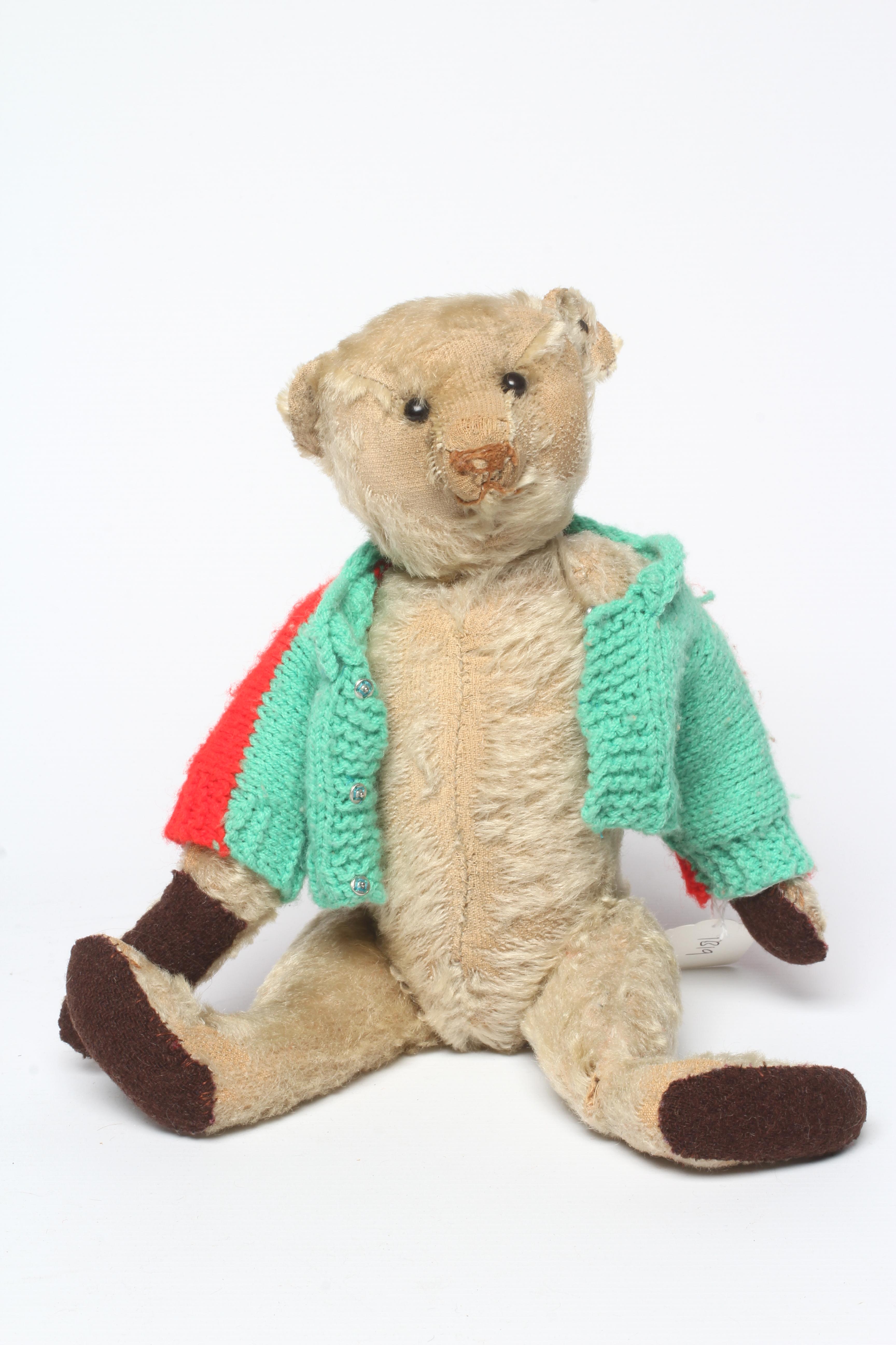 An early 20th century Steiff teddy bear with metal ear button, black shoe button eyes, light orange Image