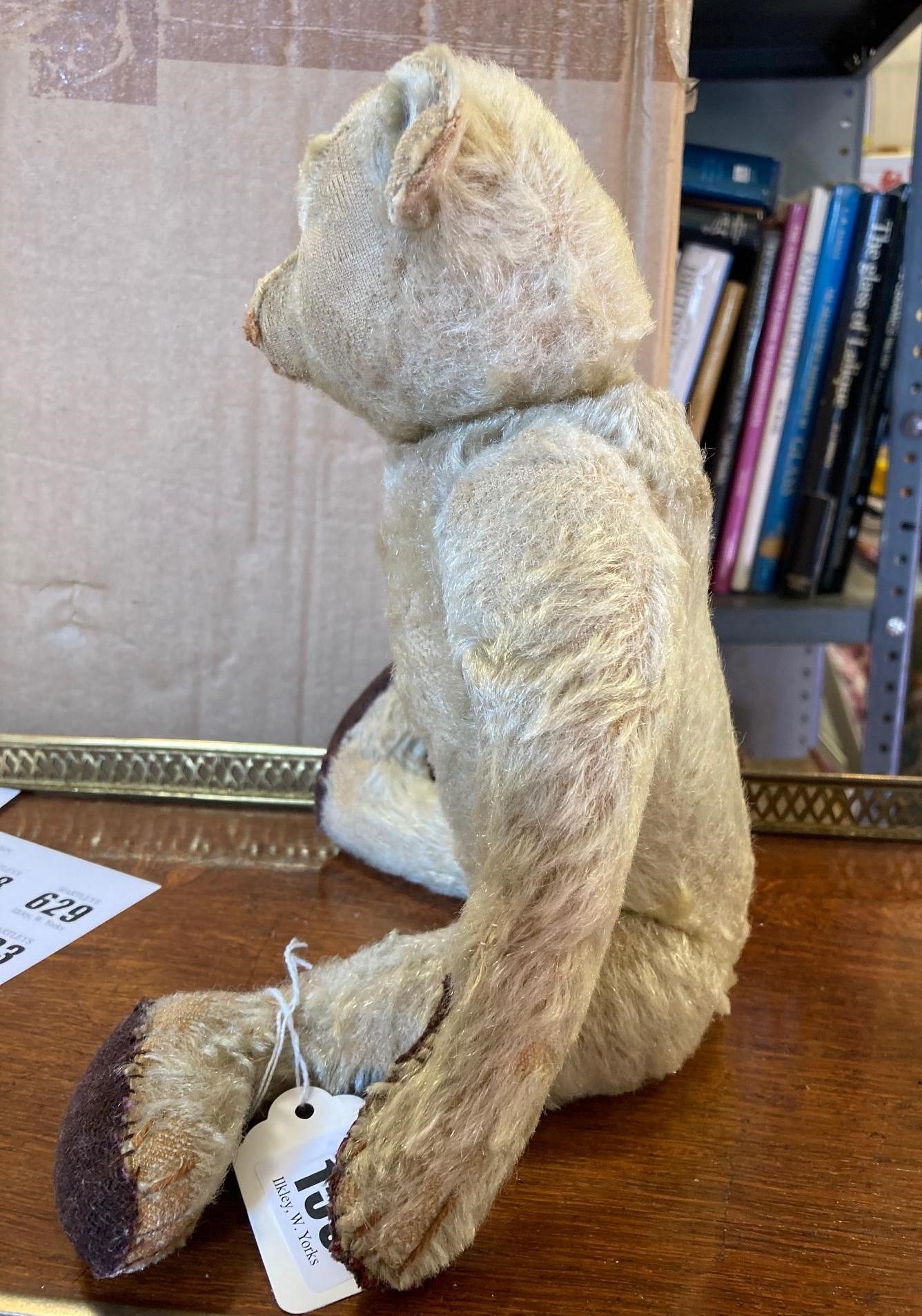 An early 20th century Steiff teddy bear with metal ear button, black shoe button eyes, light orange Image