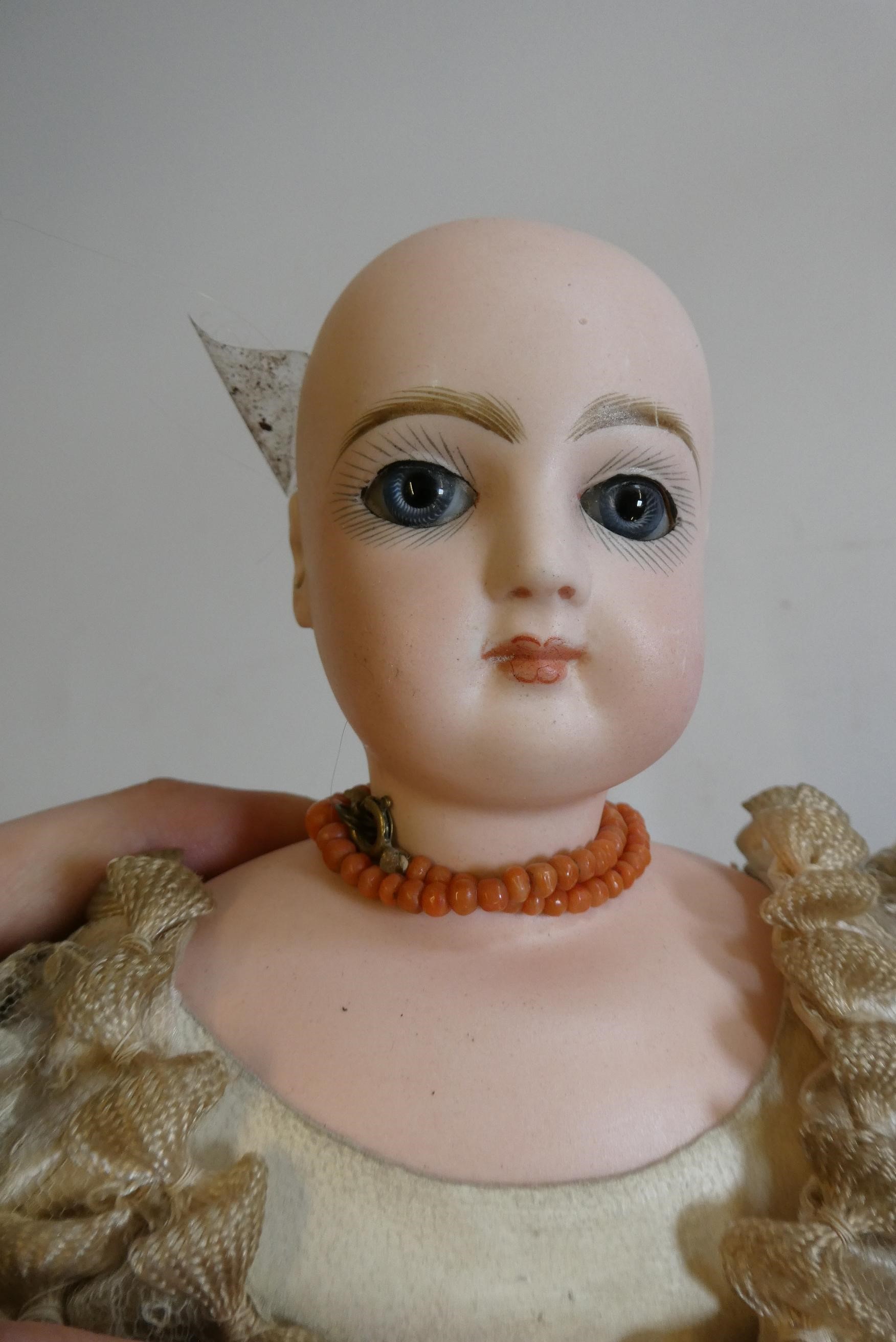 A Jumeau bisque shoulder head doll with blue glass fixed eyes Image