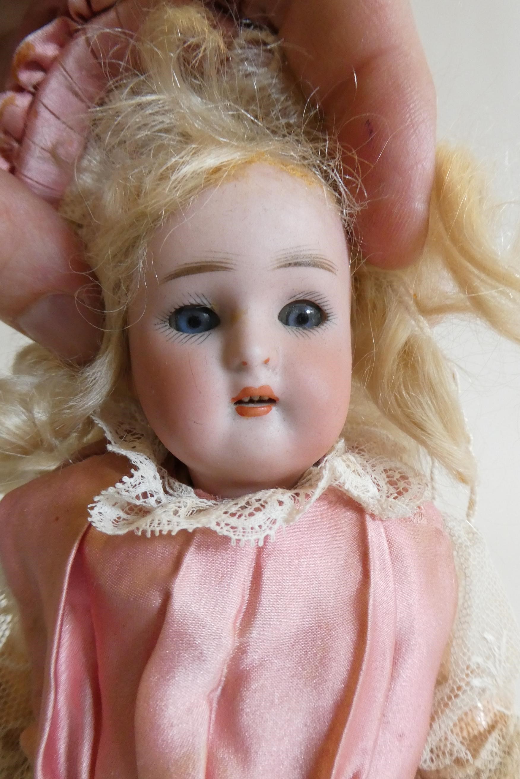 A Kammer & Reinhardt bisque socket head doll with blue glass sleeping eyes Image