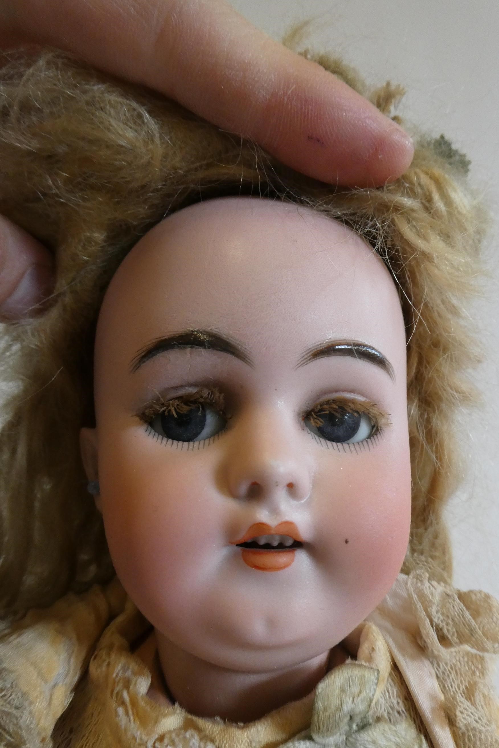 A Simon & Halbig bisque socket head clockwork walking doll with blue glass sideways glancing flirty Image