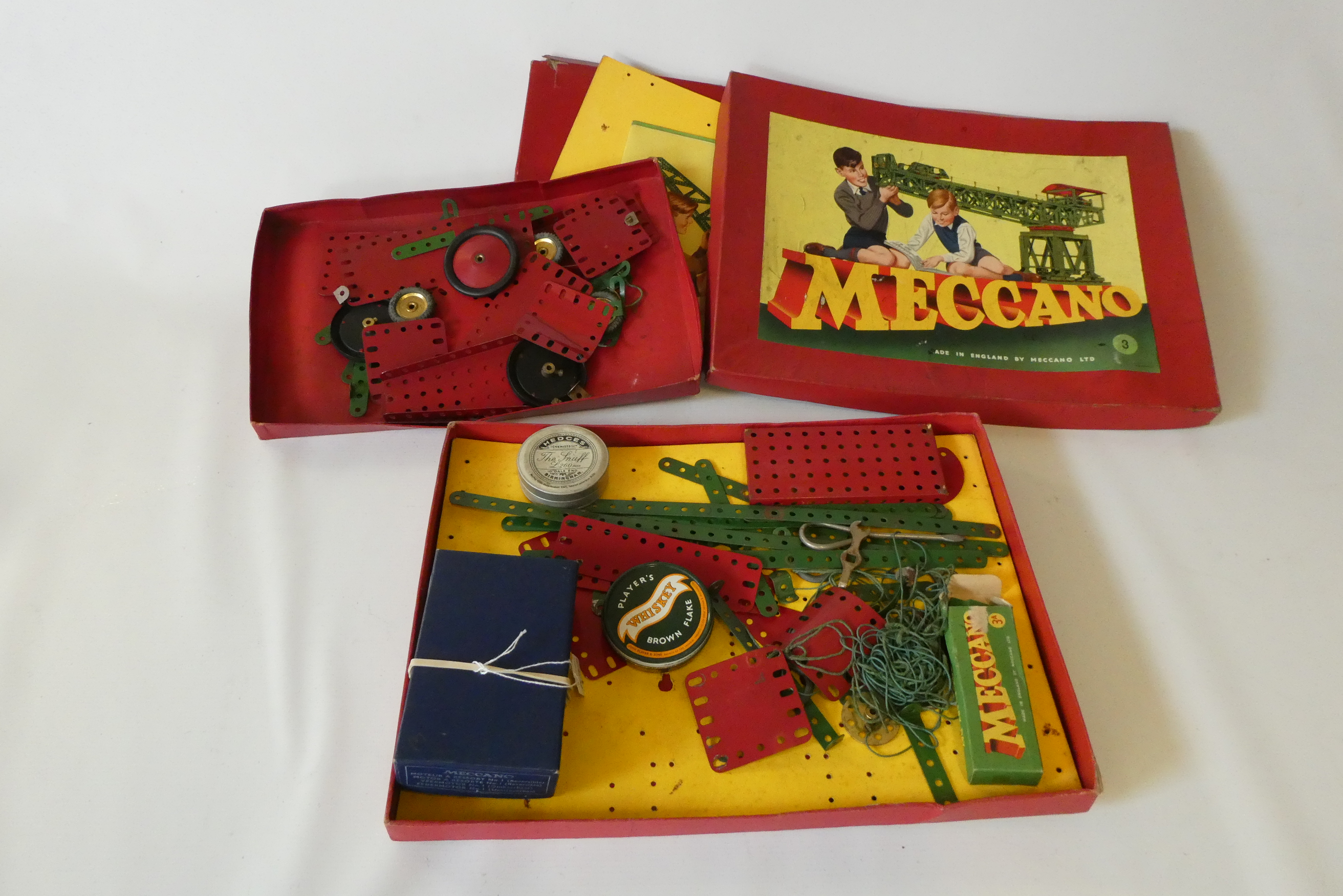Meccano red and green parts in used condition in red card boxes, fair to poor, and a No1 clockwork Image