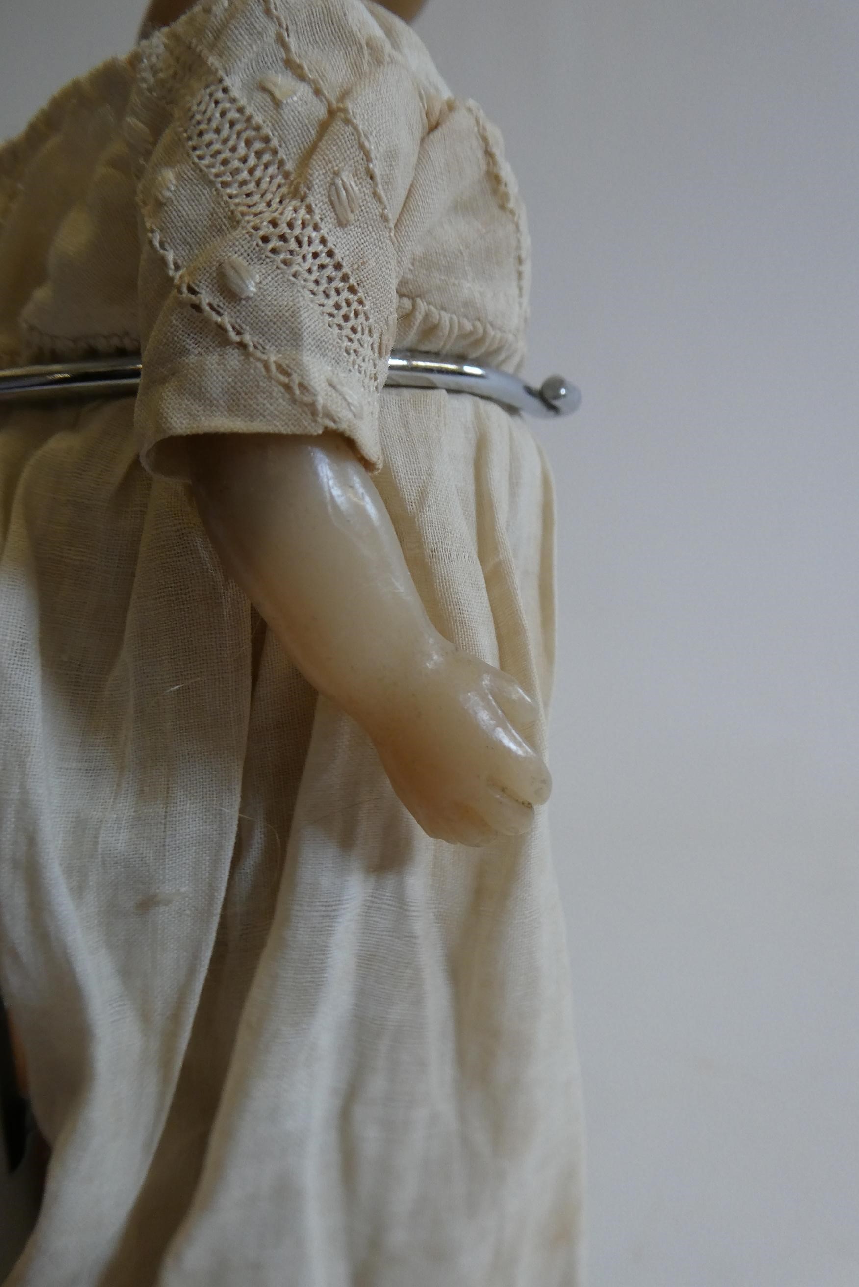 A Victorian wax shoulder head doll with blue glass fixed eyes, moulded open mouth, blond wig, fabric Image