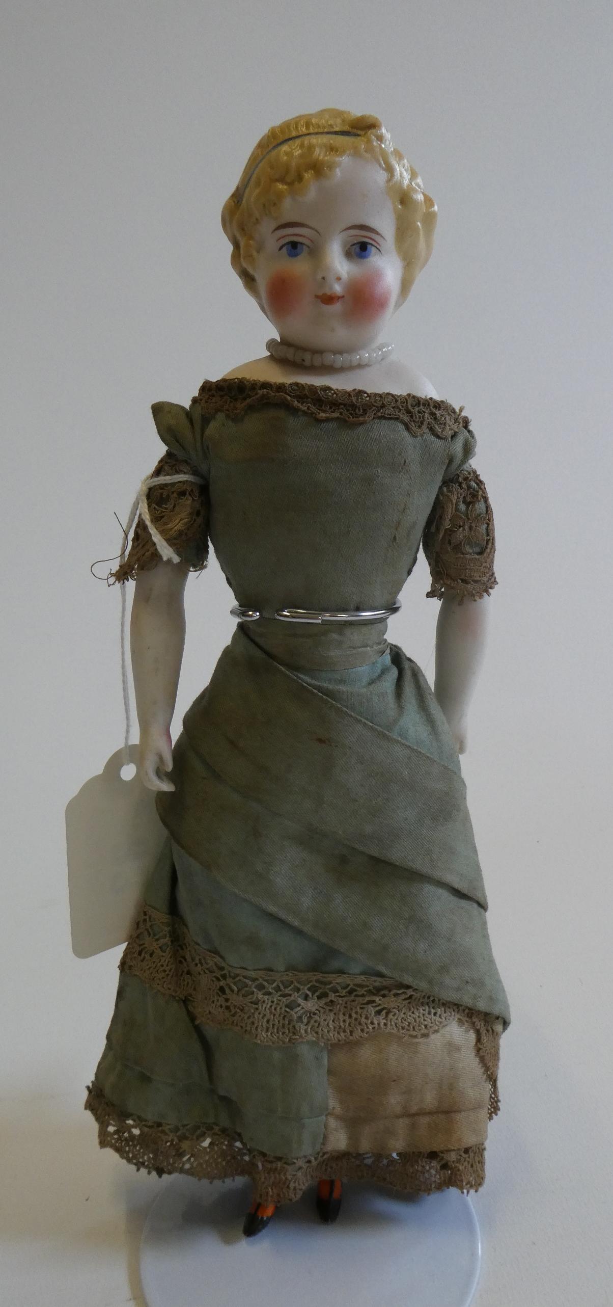 A bisque shoulder head doll, 19th century, with painted features, moulded hair, fabric body, bisque Image