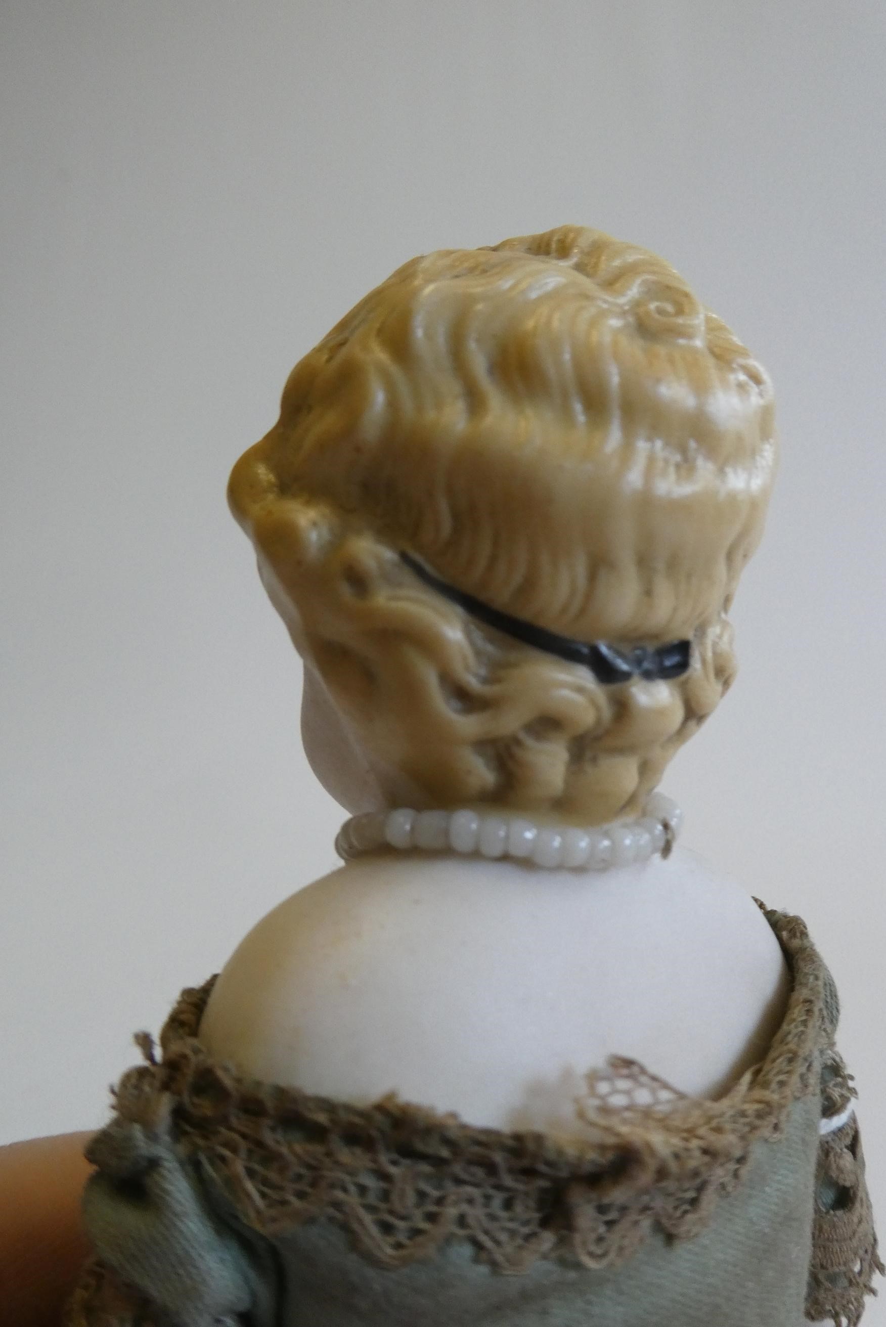 A bisque shoulder head doll, 19th century, with painted features, moulded hair, fabric body, bisque Image