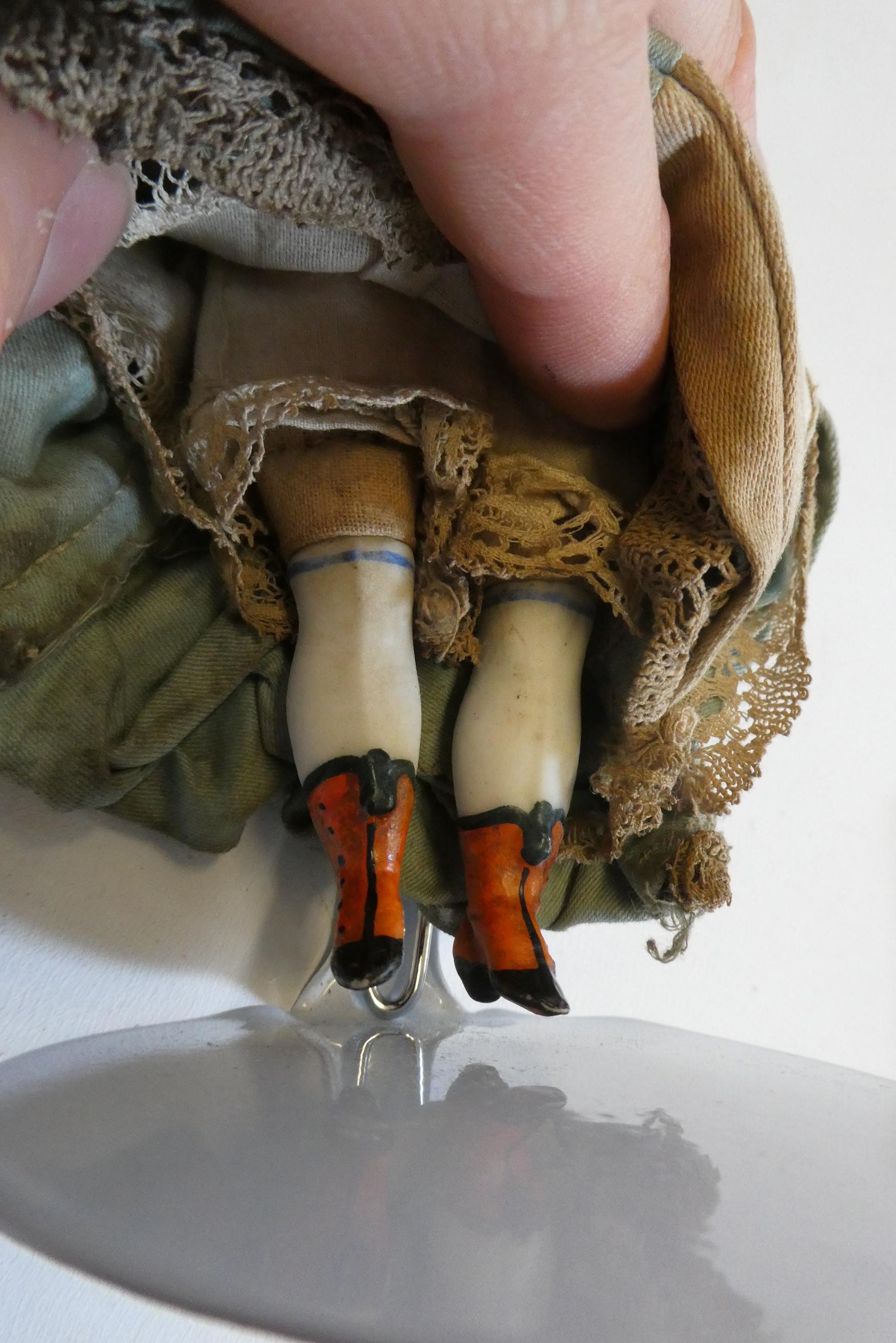 A bisque shoulder head doll, 19th century, with painted features, moulded hair, fabric body, bisque Image