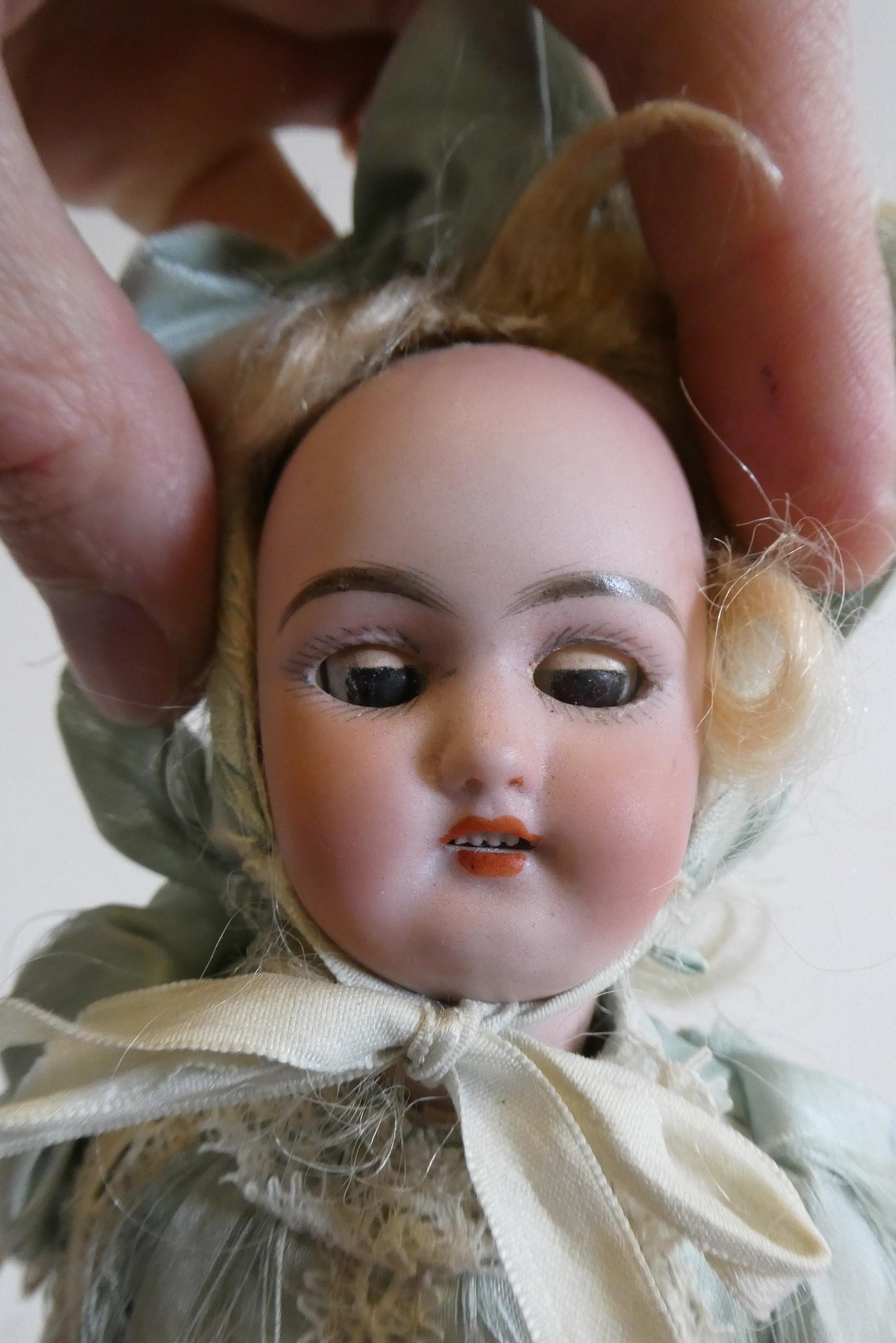 A Simon & Halbig bisque socket head doll with brown glass sleeping eyes Image
