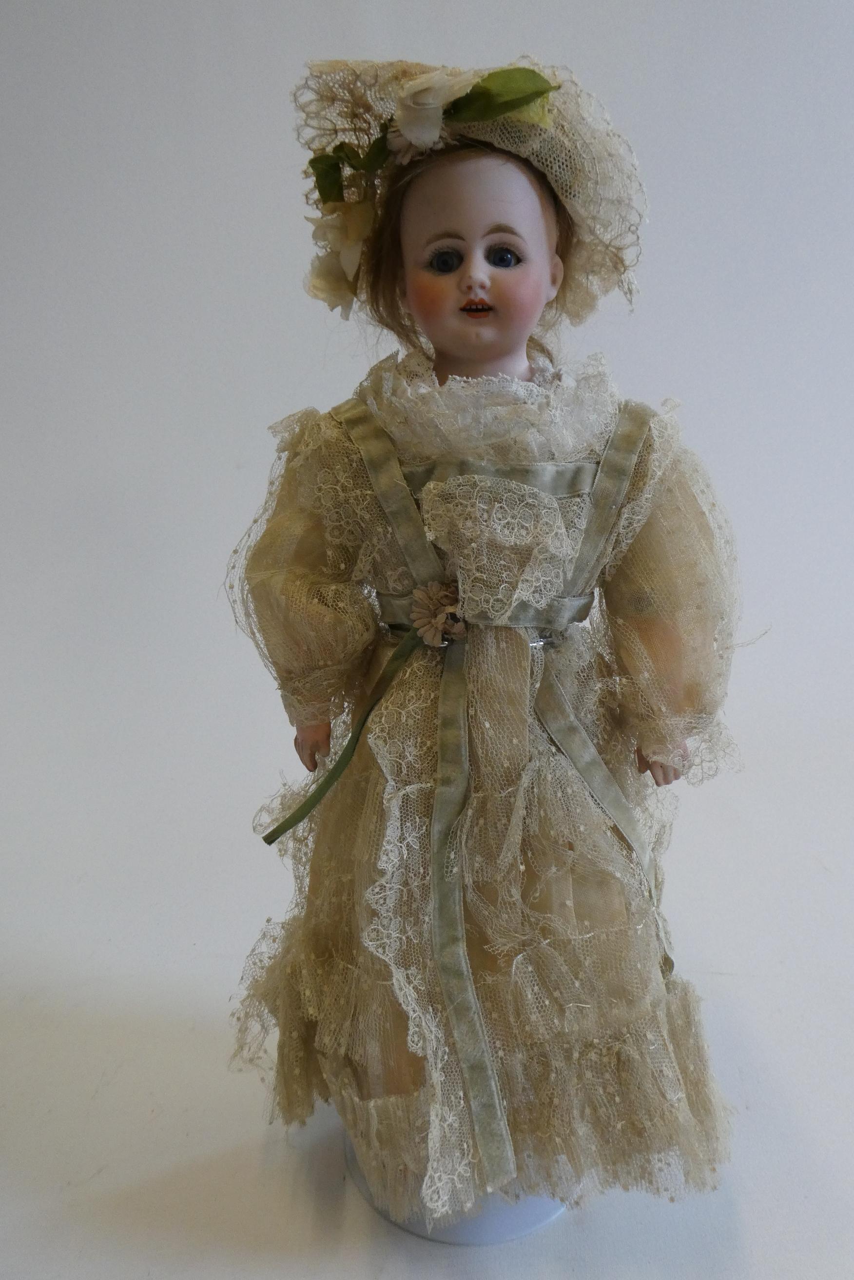 An early Armand Marseille bisque shoulder head doll with blue glass fixed eyes Image