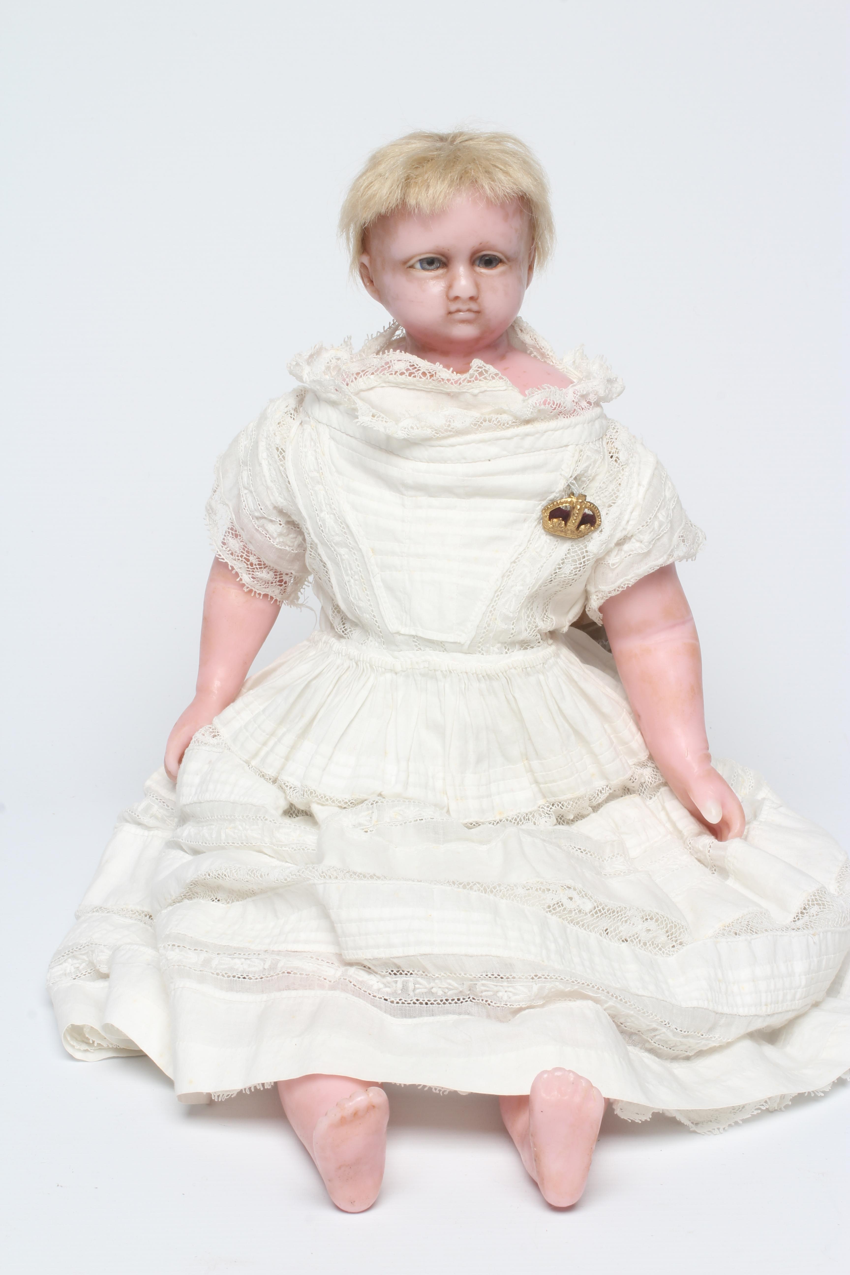 A Victorian wax shoulder head doll, with blue glass paperweight eyes, closed mouth, inserted blond Image