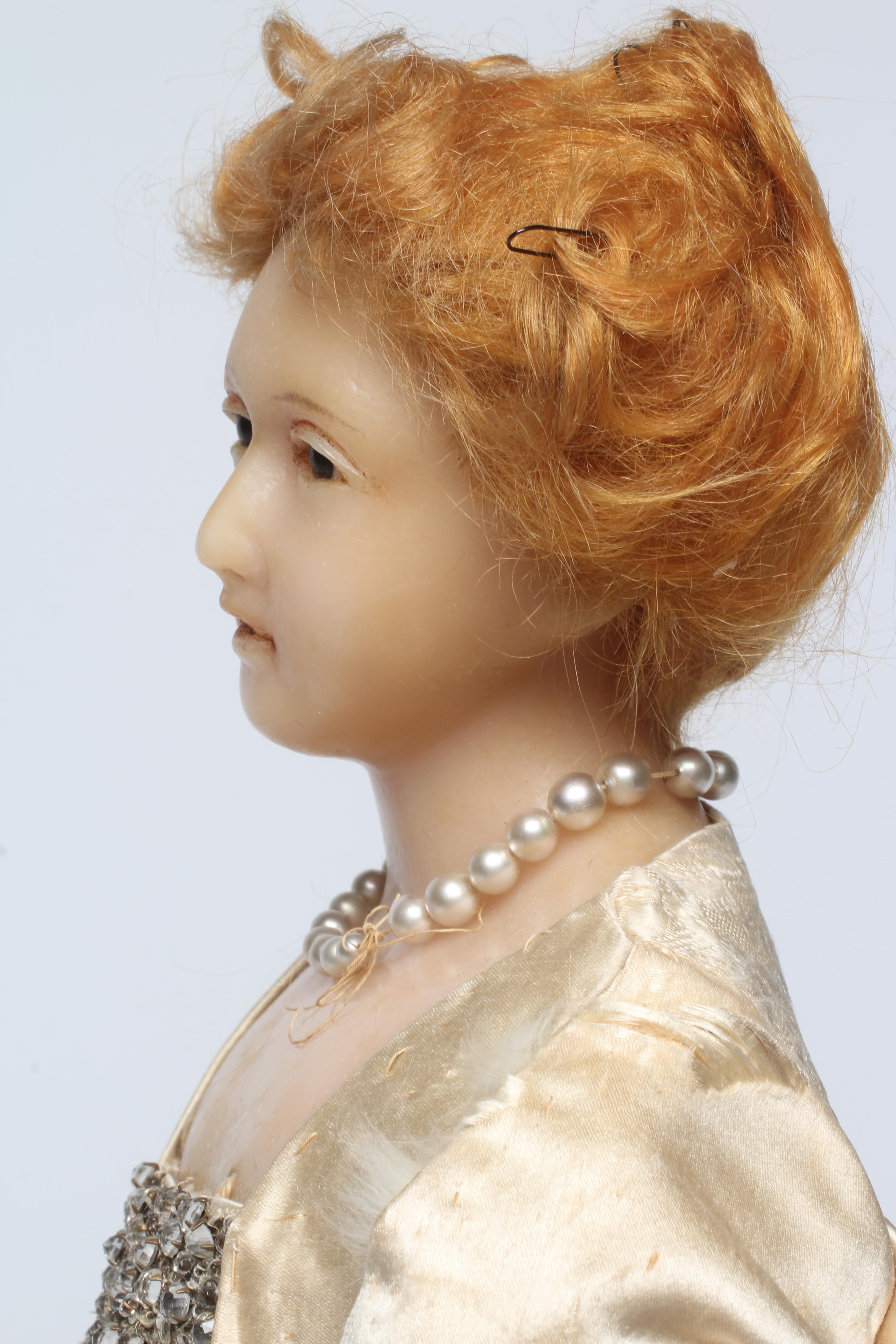 A high quality Victorian wax shoulder head doll with brown glass fixed eyes Image