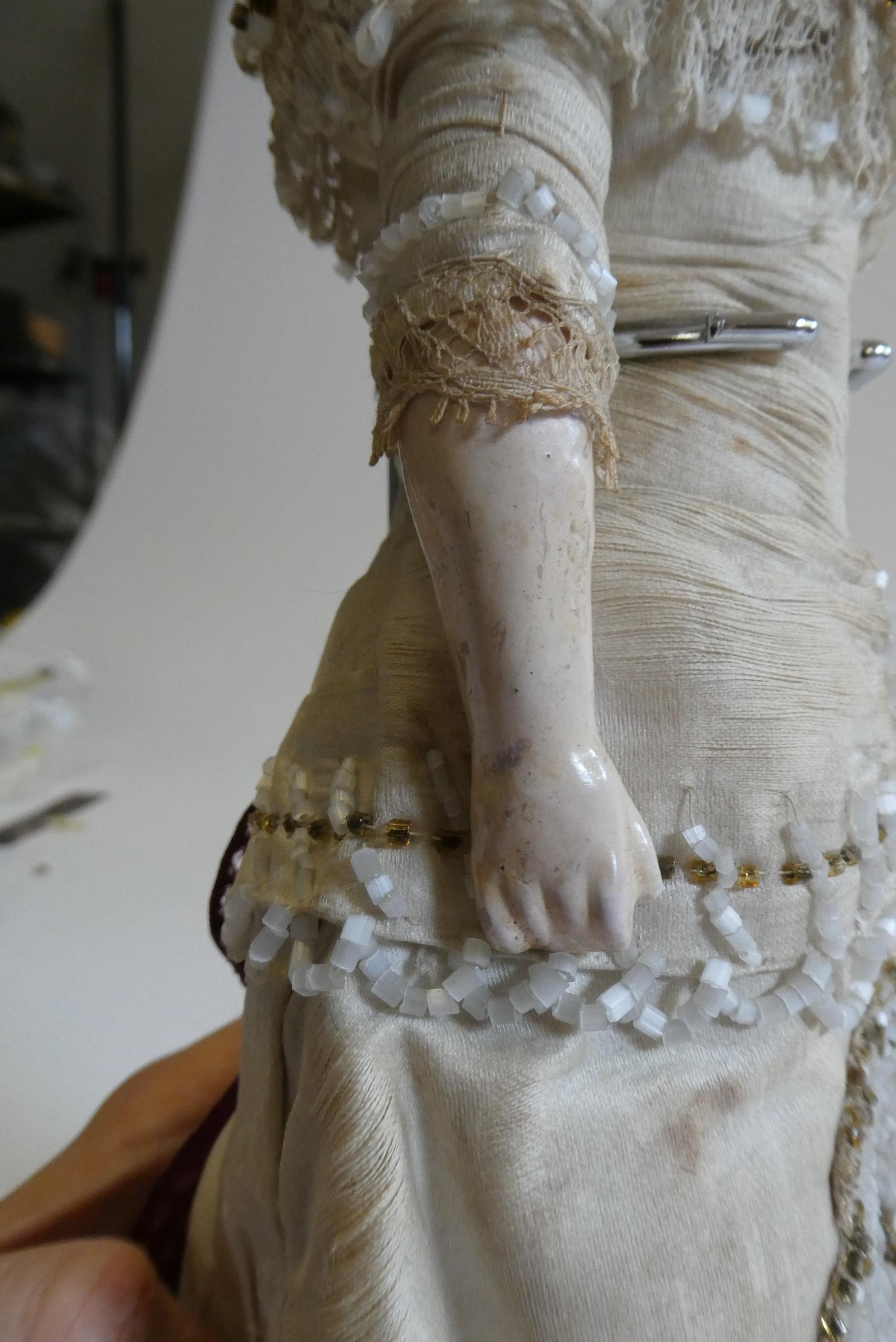 A Victorian wax shoulder head doll with blue glass paperweight fixed eyes Image