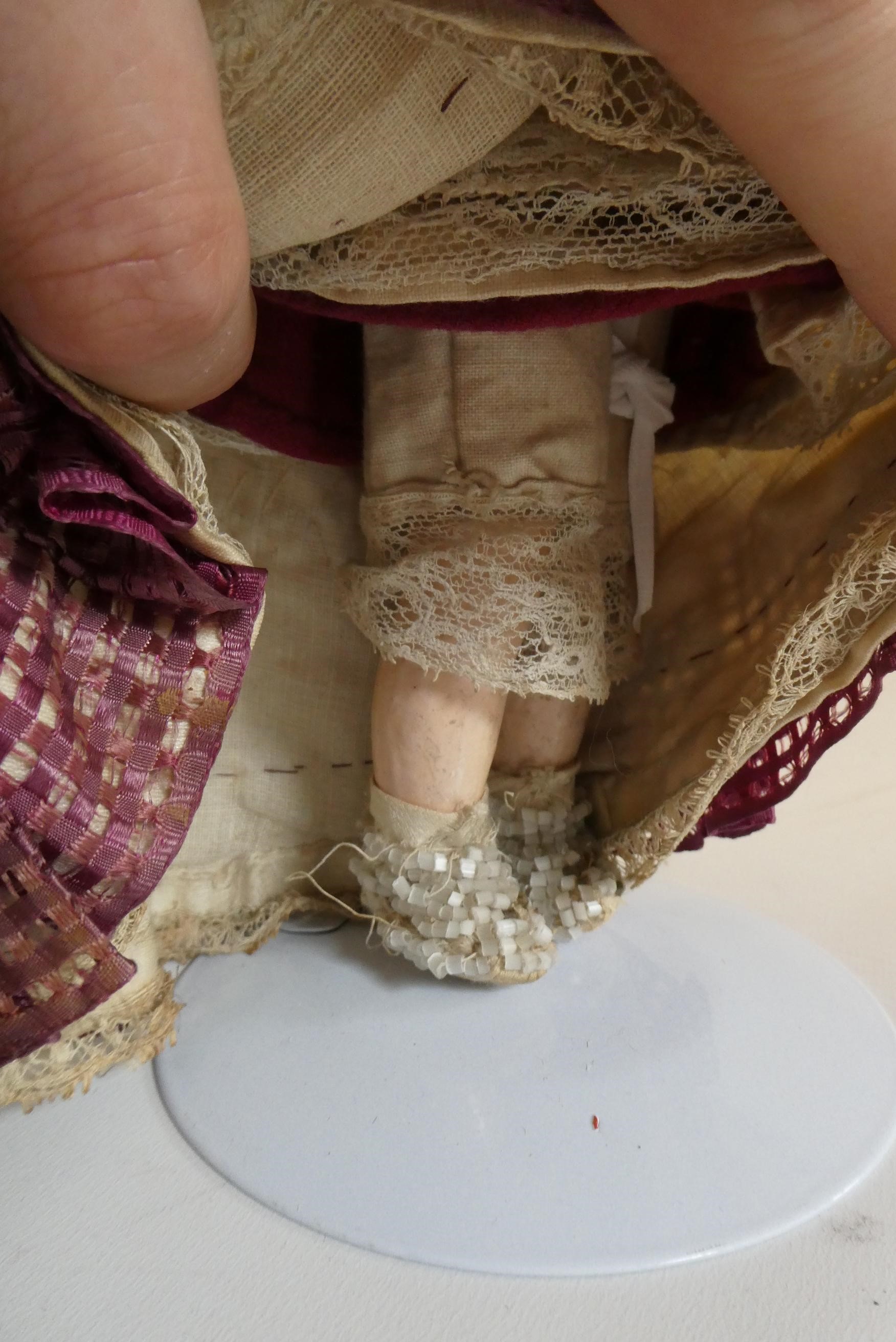 A Victorian wax shoulder head doll with blue glass paperweight fixed eyes Image