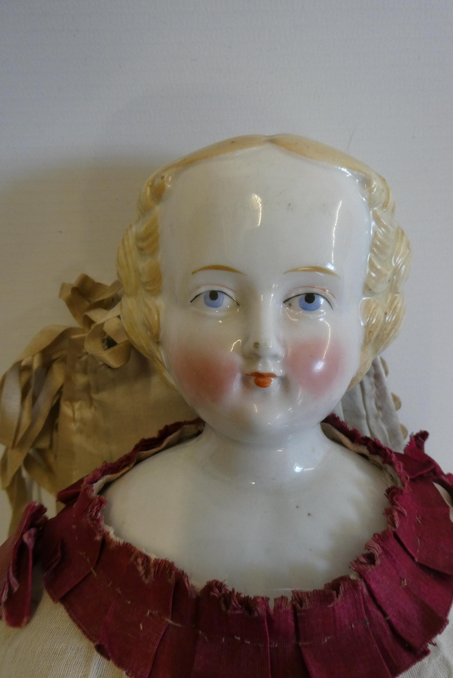 A Victorian china shoulder head doll with painted features, moulded hair, jointed kid body, lace Image