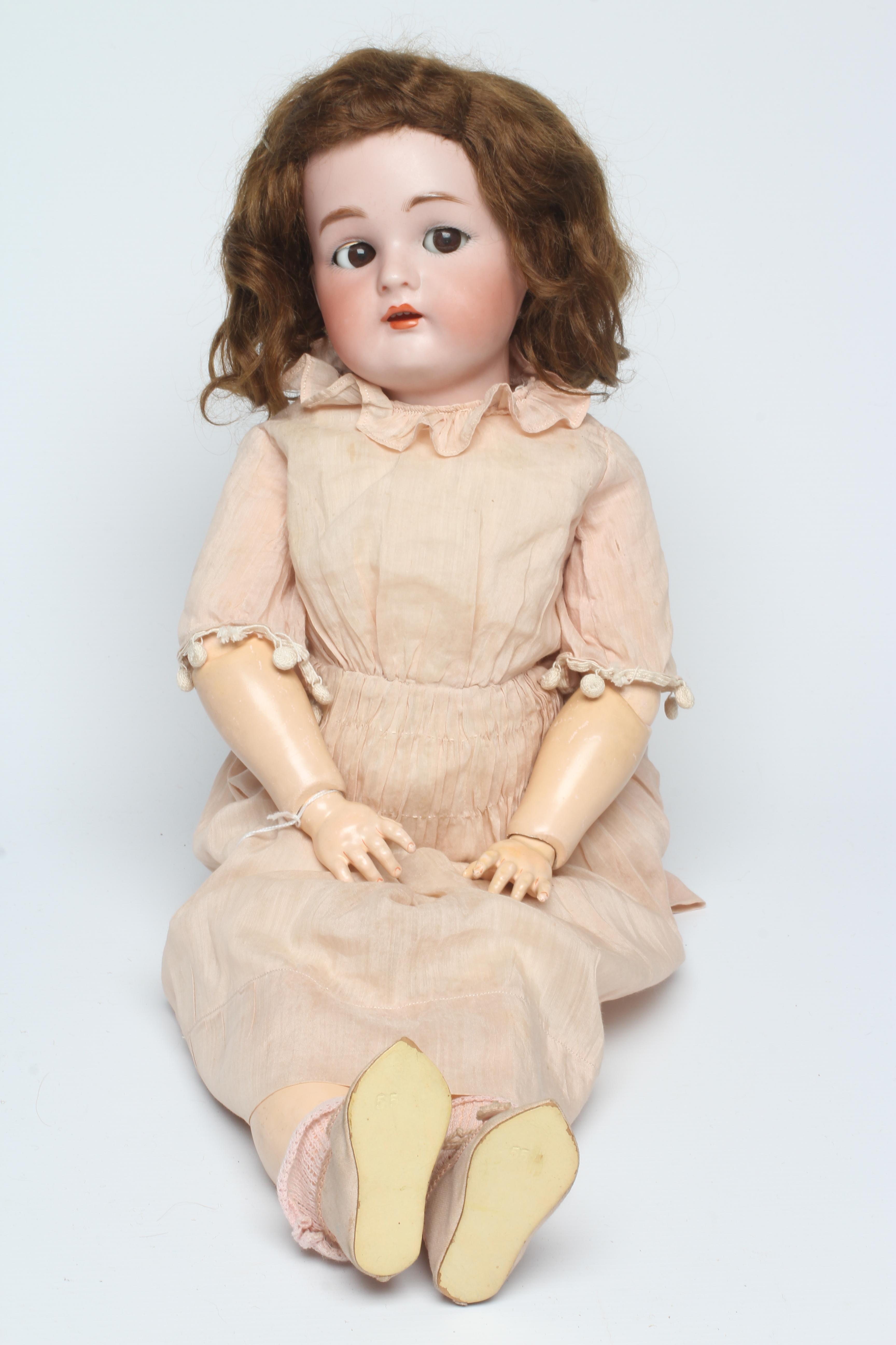 A Simon & Halbig Kammer & Reinhardt bisque socket head doll with brown glass sideways glancing Image