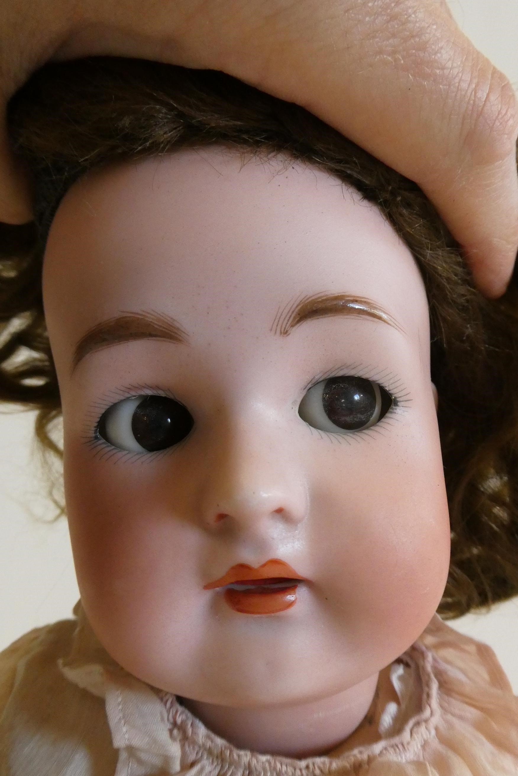 A Simon & Halbig Kammer & Reinhardt bisque socket head doll with brown glass sideways glancing Image