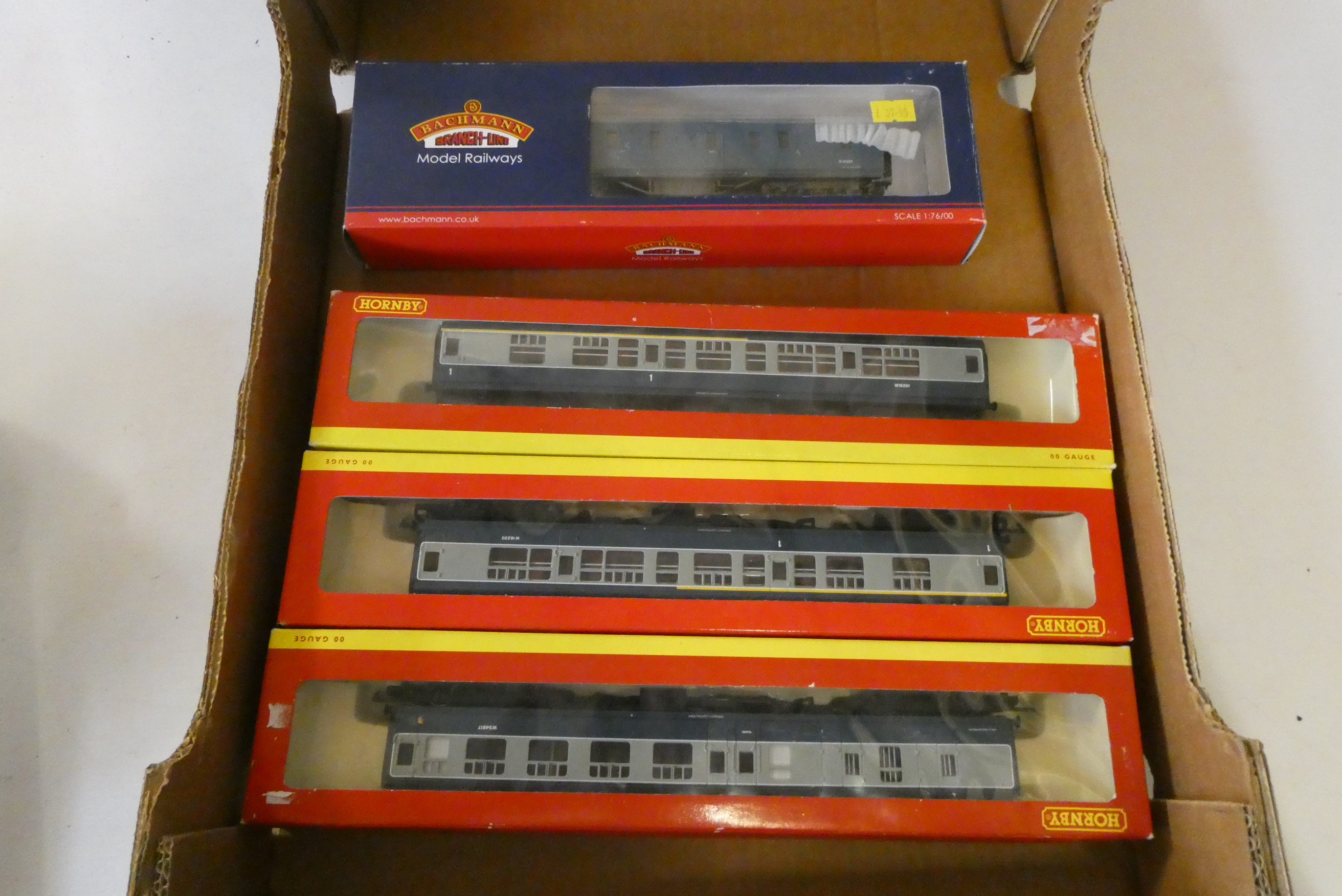Three Hornby BR blue/grey passenger coaches and Bachmann BR blue weathered parcels van, all items Image