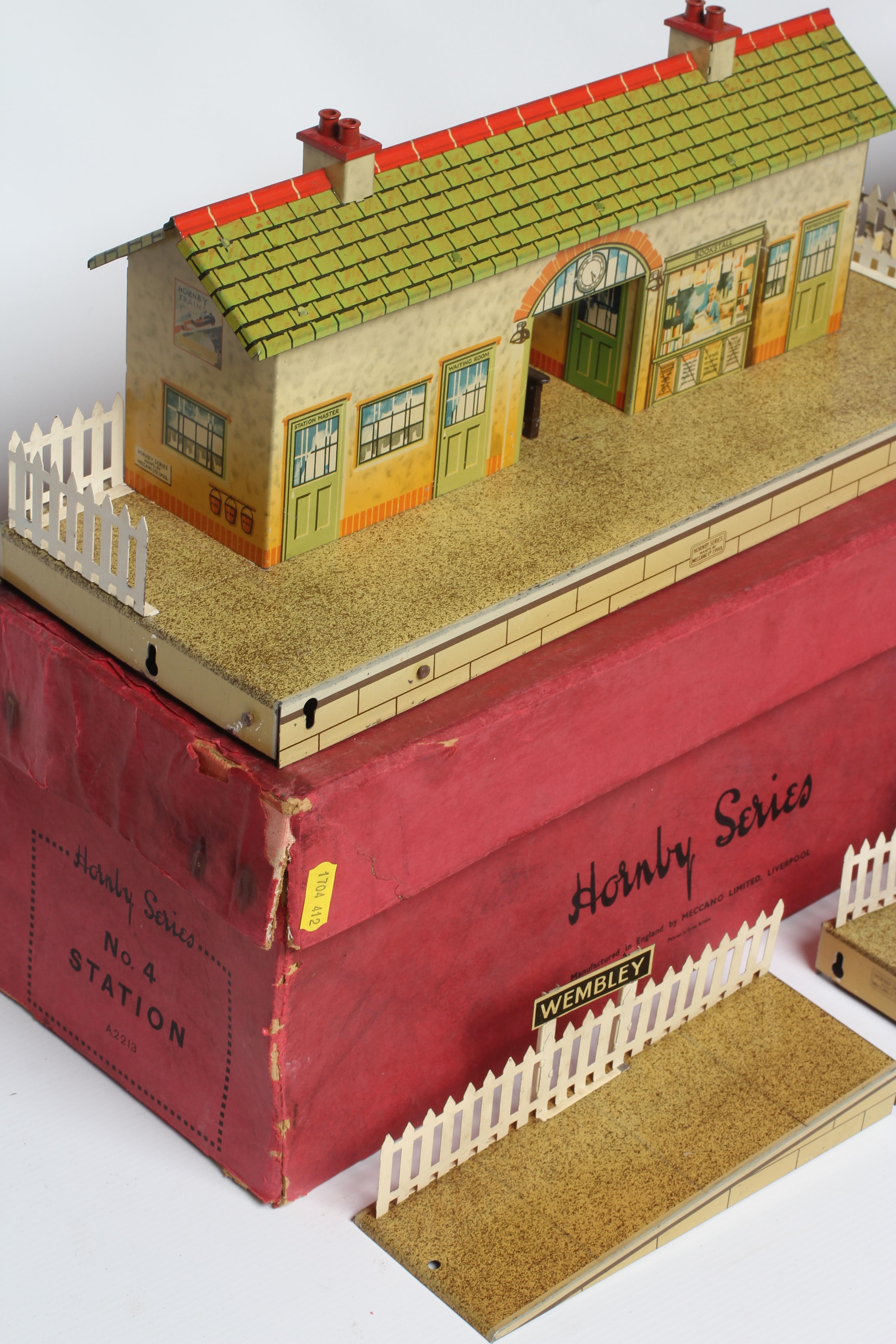 Hornby O gauge station, No 4 with signs for Wembley, together with a No 3, both boxed, items good, Image