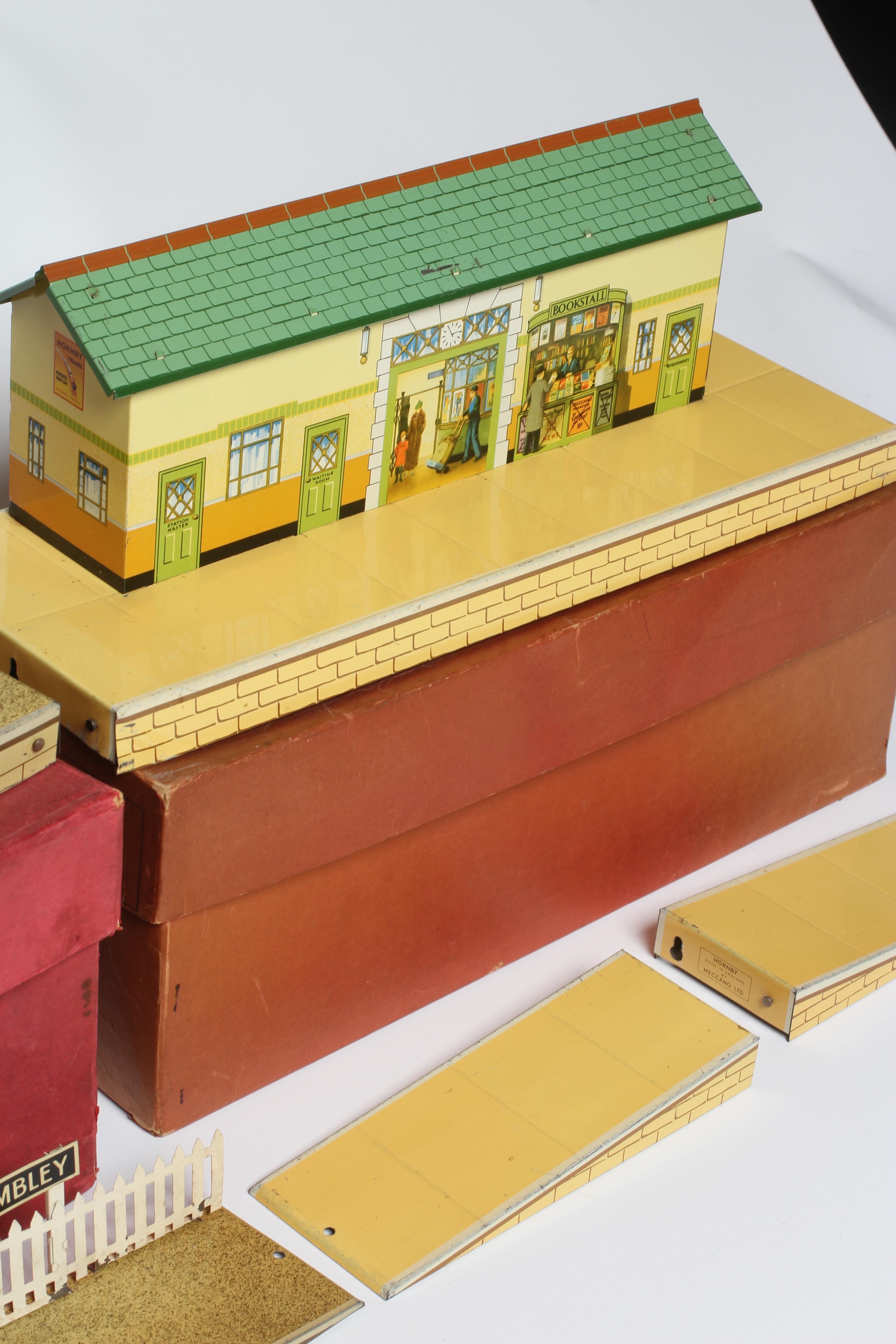 Hornby O gauge station, No 4 with signs for Wembley, together with a No 3, both boxed, items good, Image