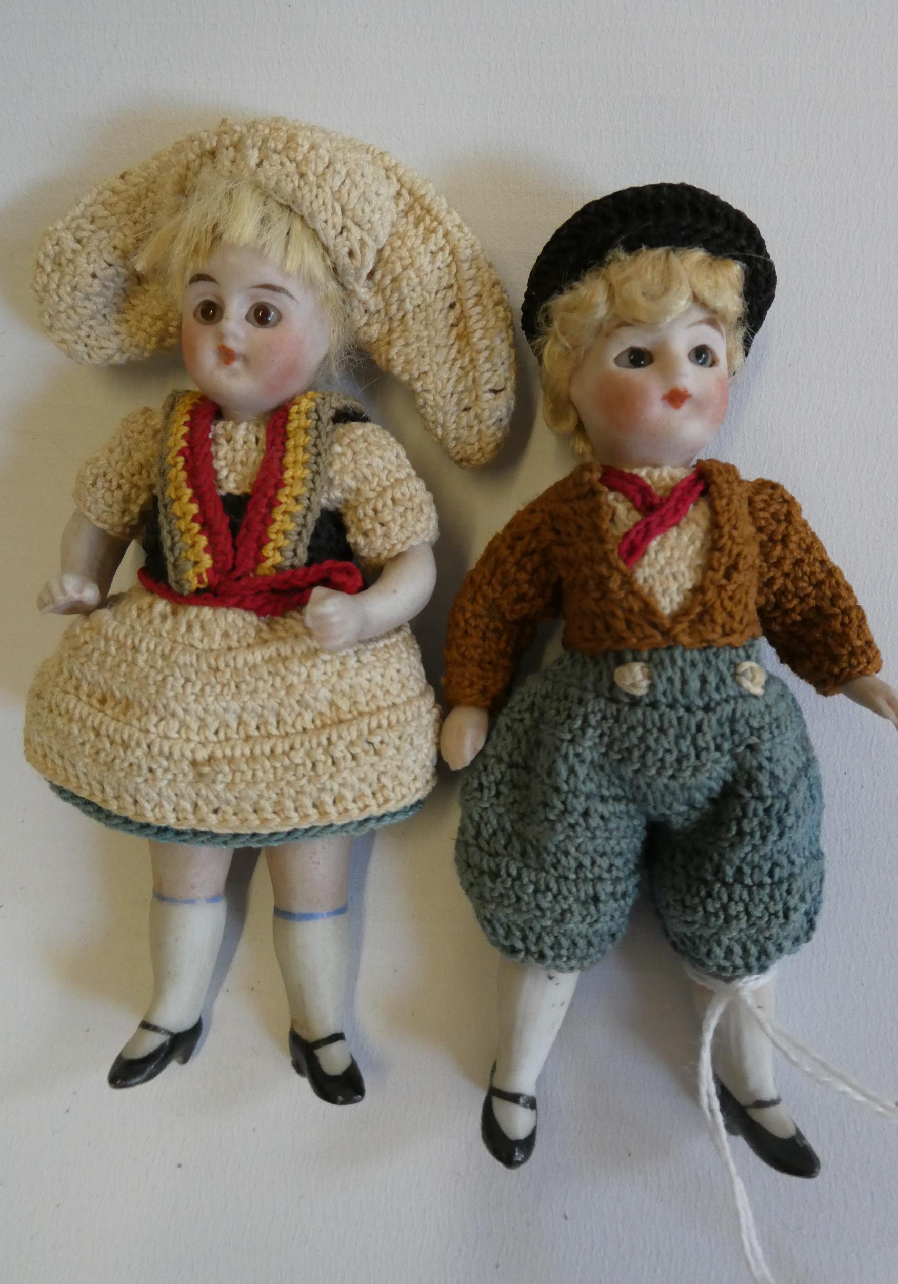 A pair of all bisque doll's house dolls, with five piece bodies, brown glass fixed eyes, moulded and Image