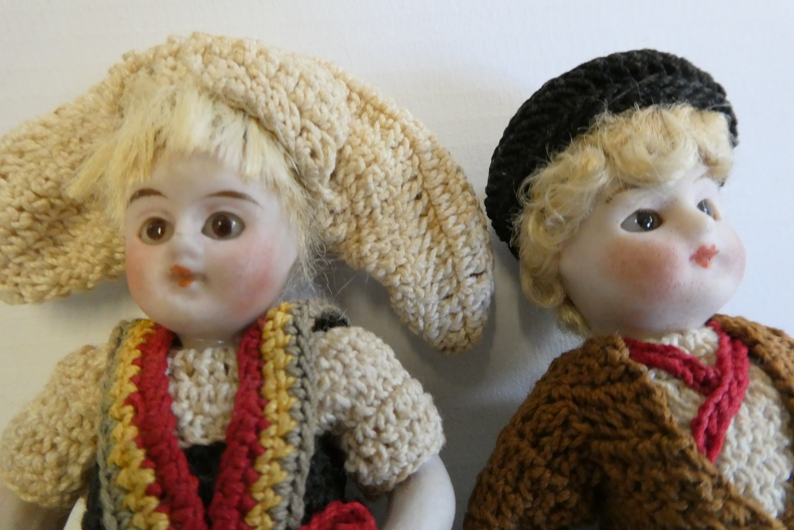 A pair of all bisque doll's house dolls, with five piece bodies, brown glass fixed eyes, moulded and Image