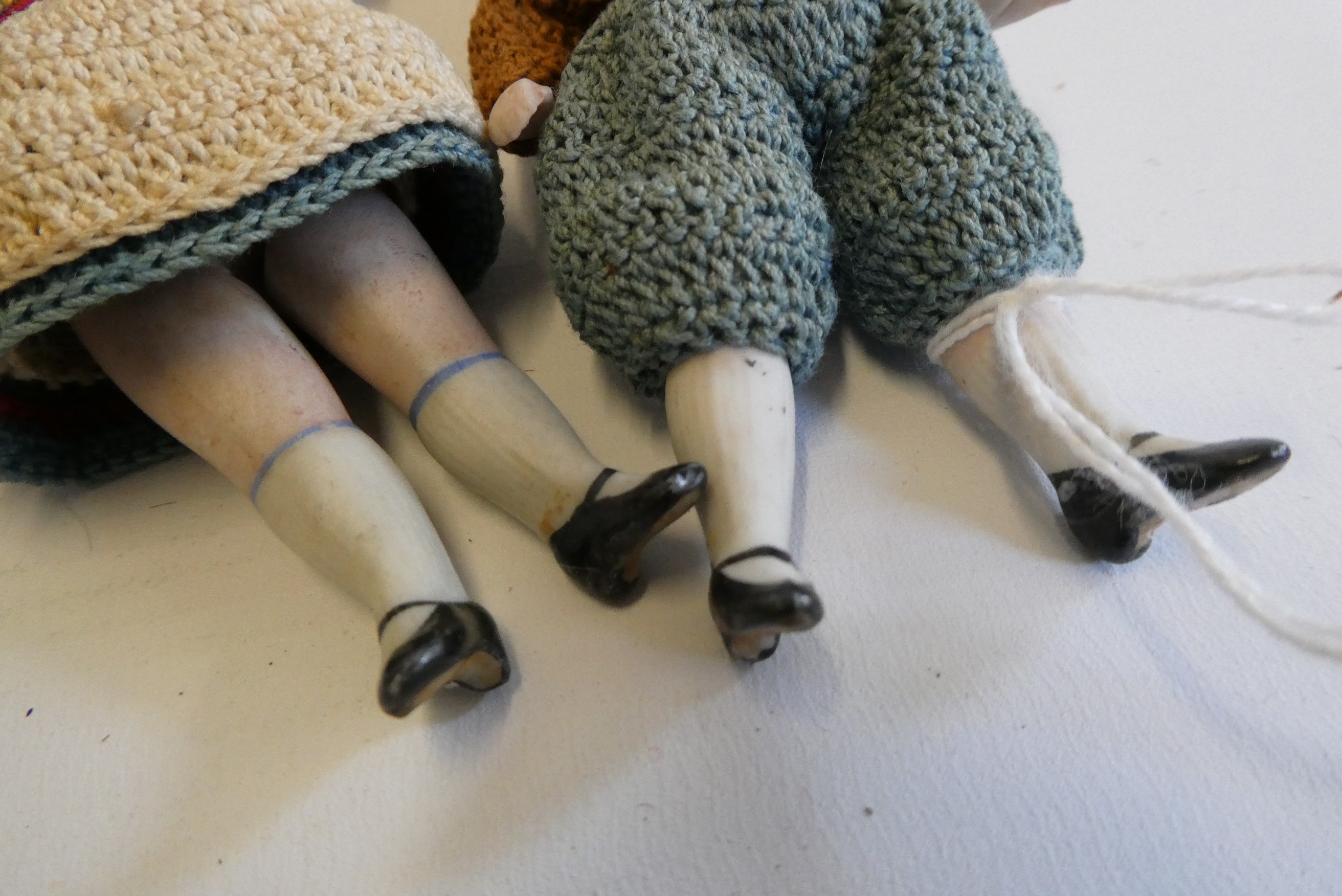 A pair of all bisque doll's house dolls, with five piece bodies, brown glass fixed eyes, moulded and Image