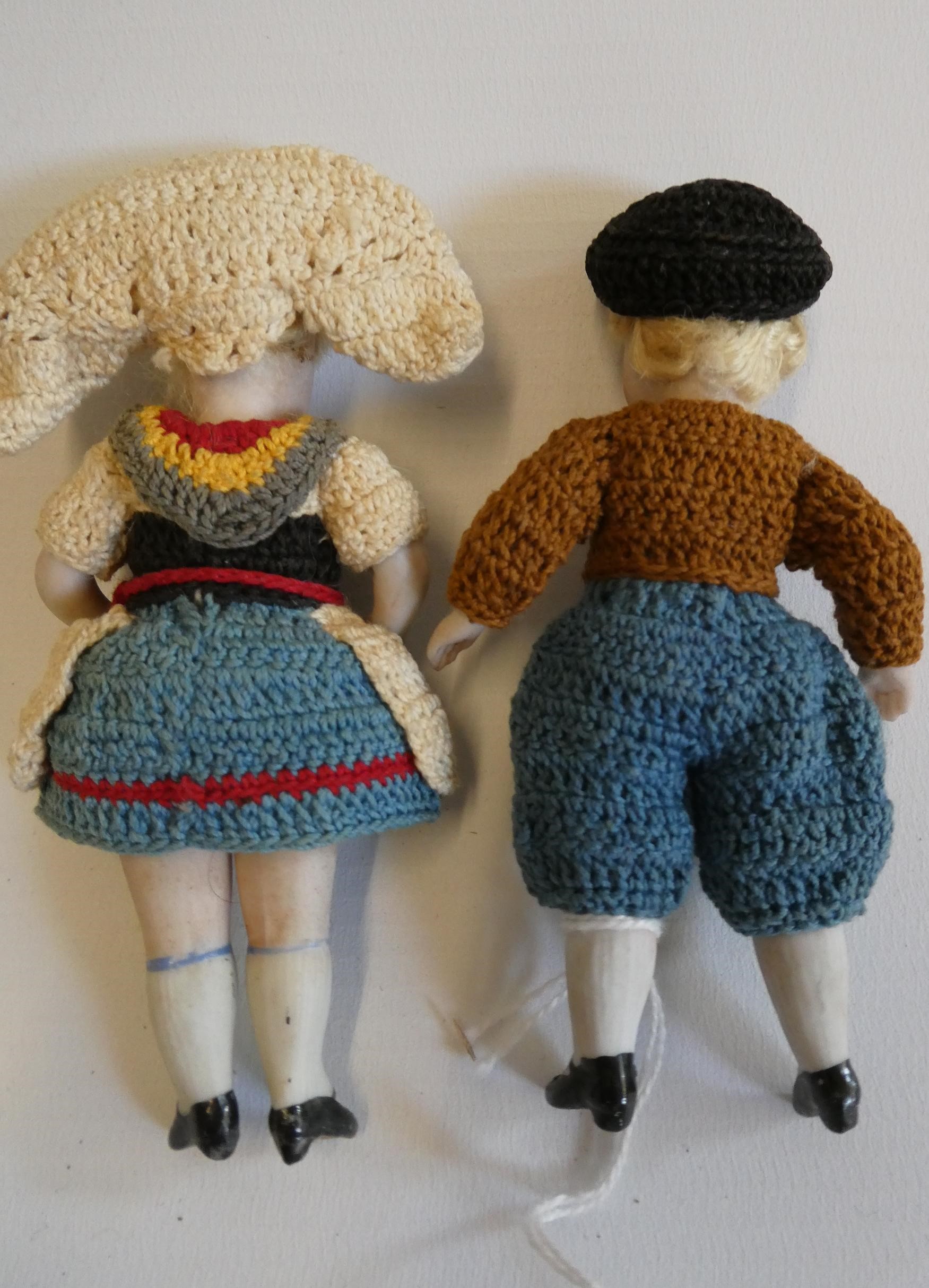 A pair of all bisque doll's house dolls, with five piece bodies, brown glass fixed eyes, moulded and Image