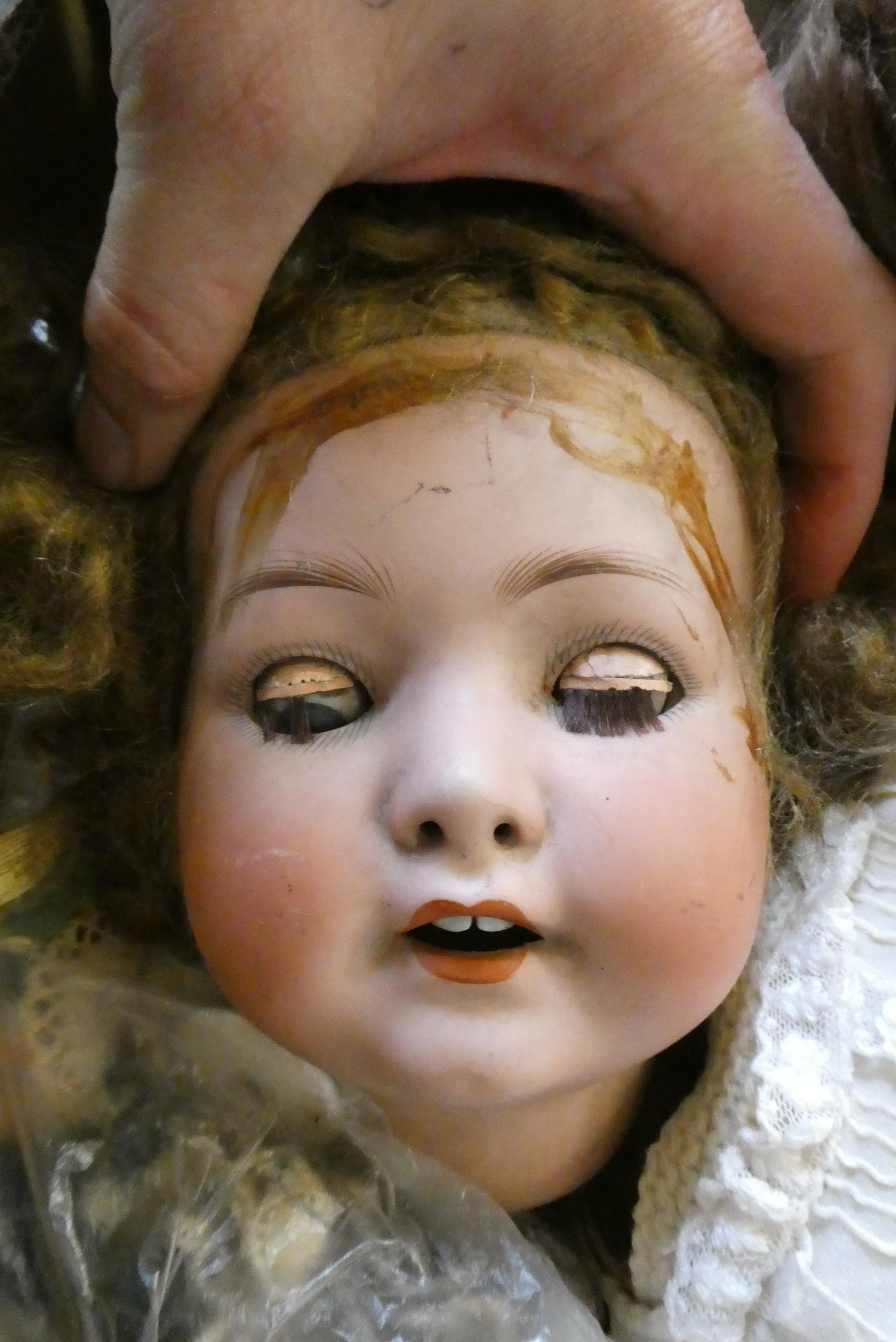 A box of dolls, parts, clothes, hats and accessories including an antique wax doll, Image