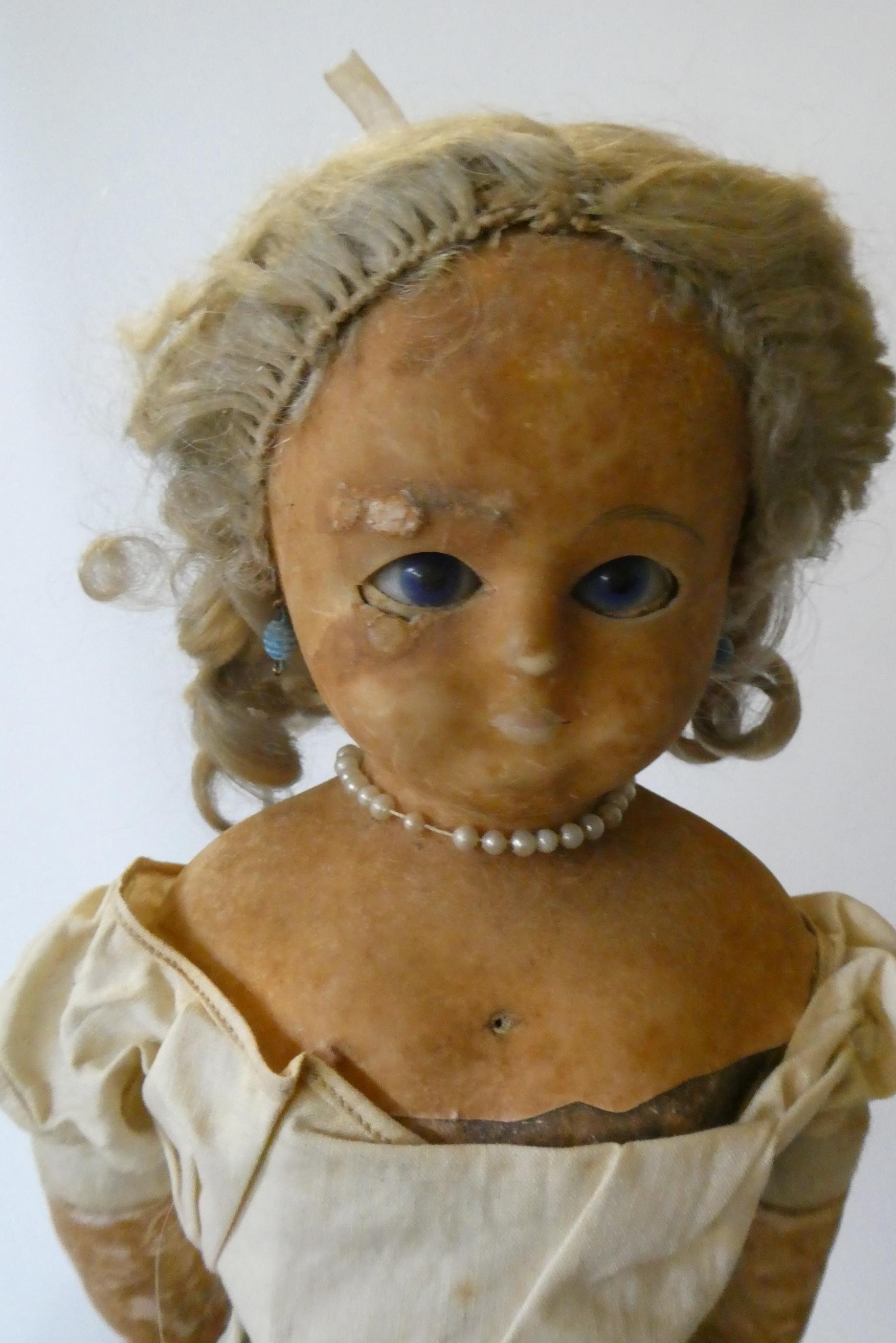 A box of dolls, parts, clothes, hats and accessories including an antique wax doll, Image