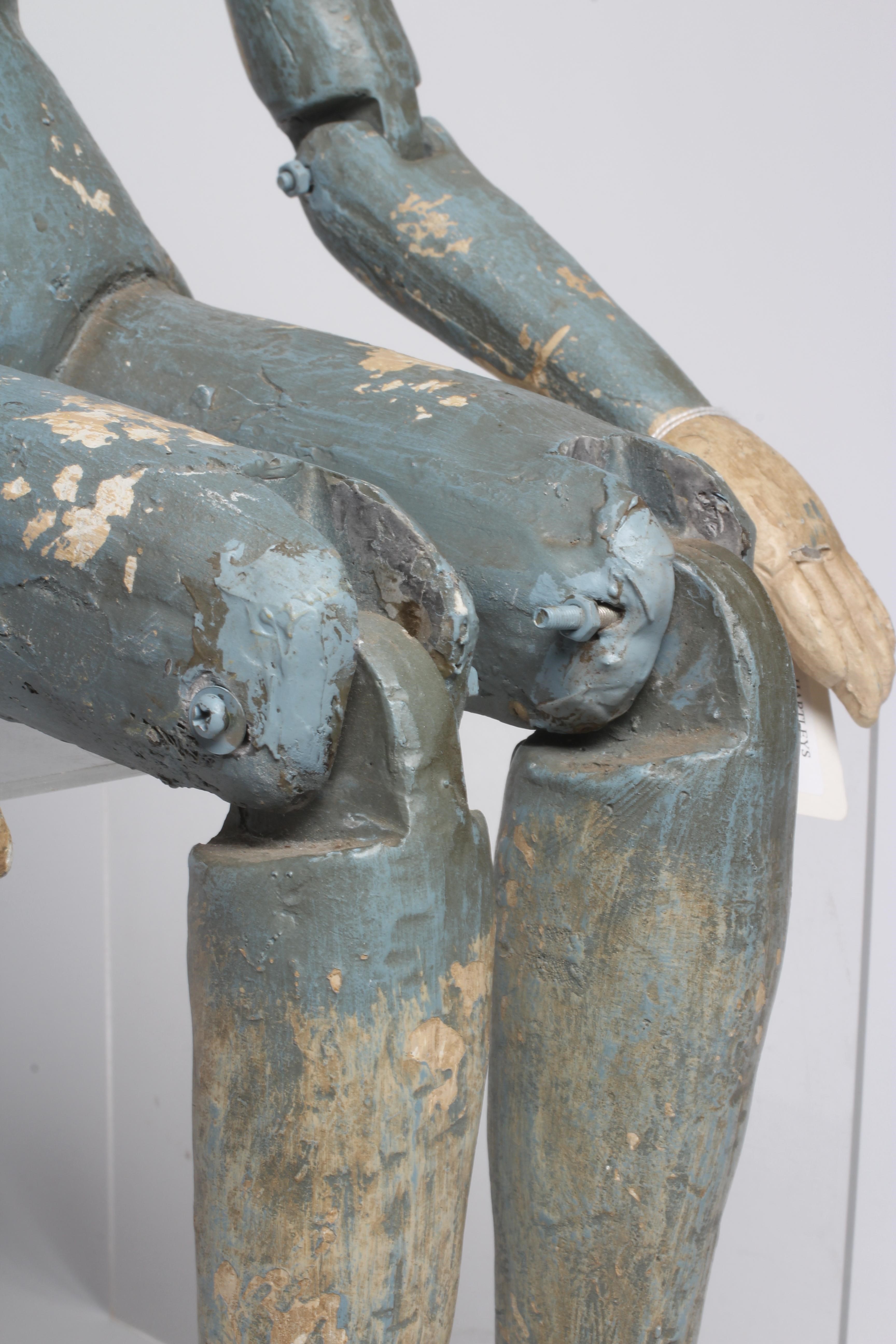 An antique seated Santos doll, of jointed wood and plaster carved construction, polychrome painted Image