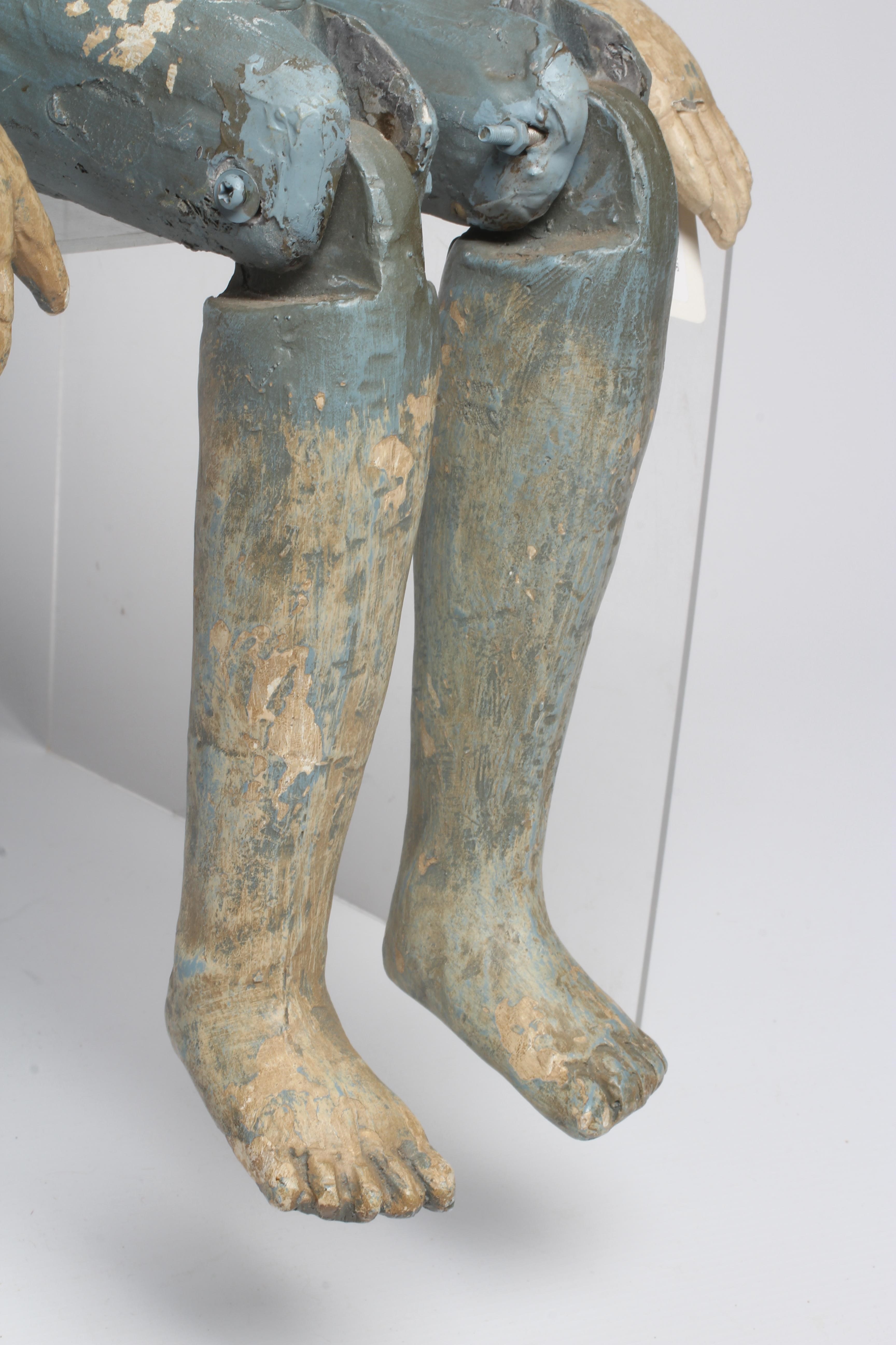 An antique seated Santos doll, of jointed wood and plaster carved construction, polychrome painted Image