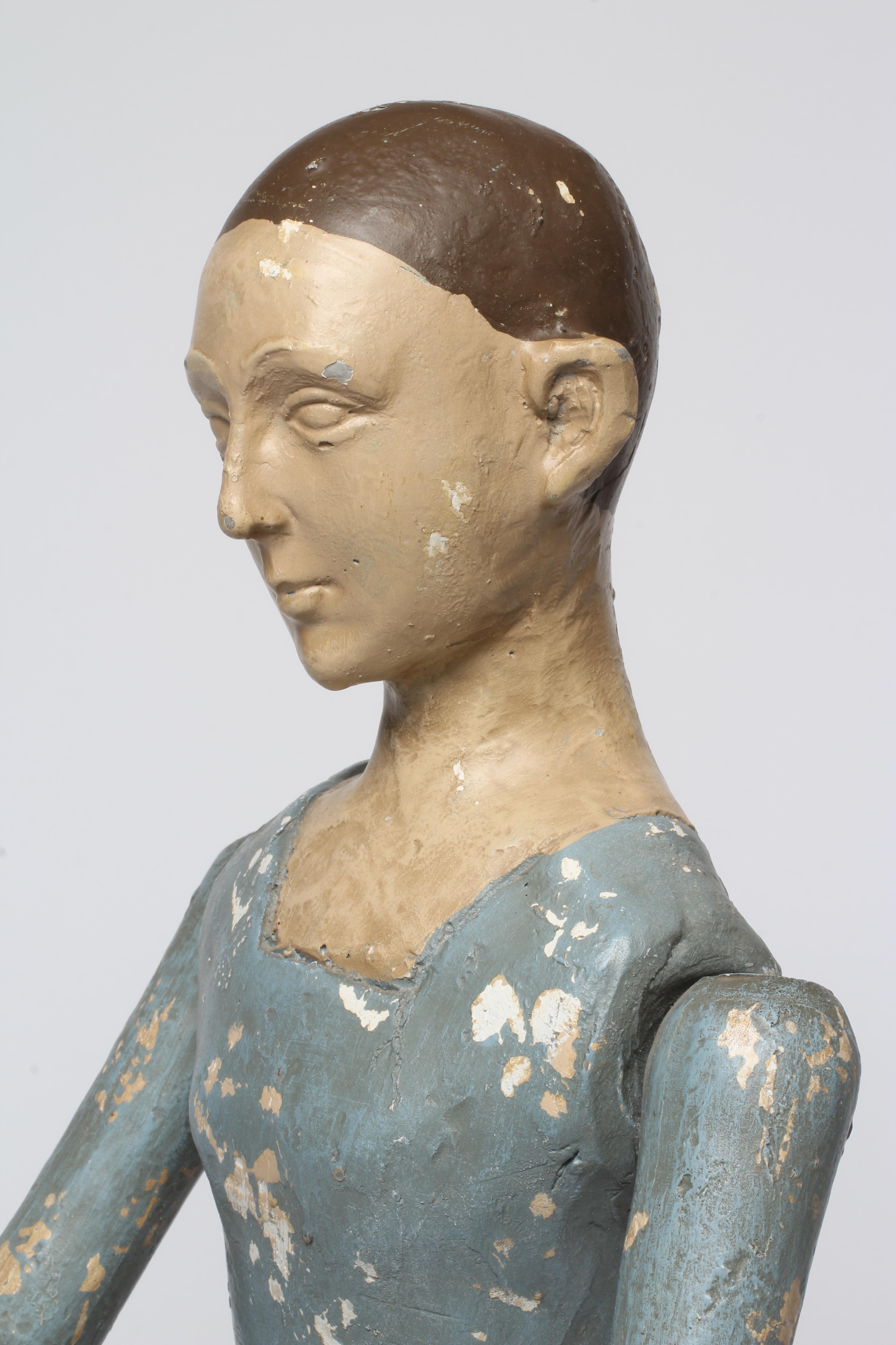 An antique seated Santos doll, of jointed wood and plaster carved construction, polychrome painted Image