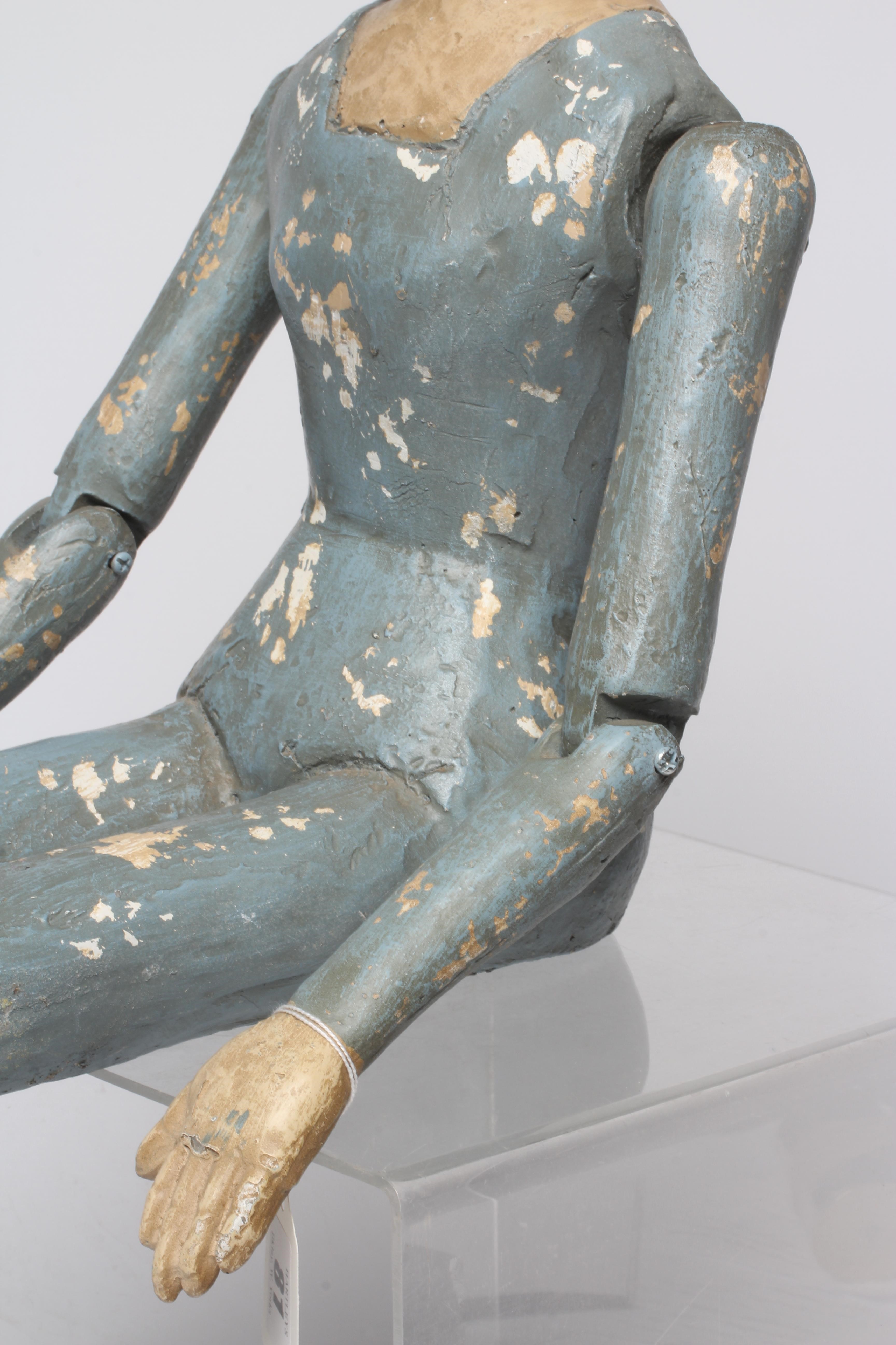 An antique seated Santos doll, of jointed wood and plaster carved construction, polychrome painted Image